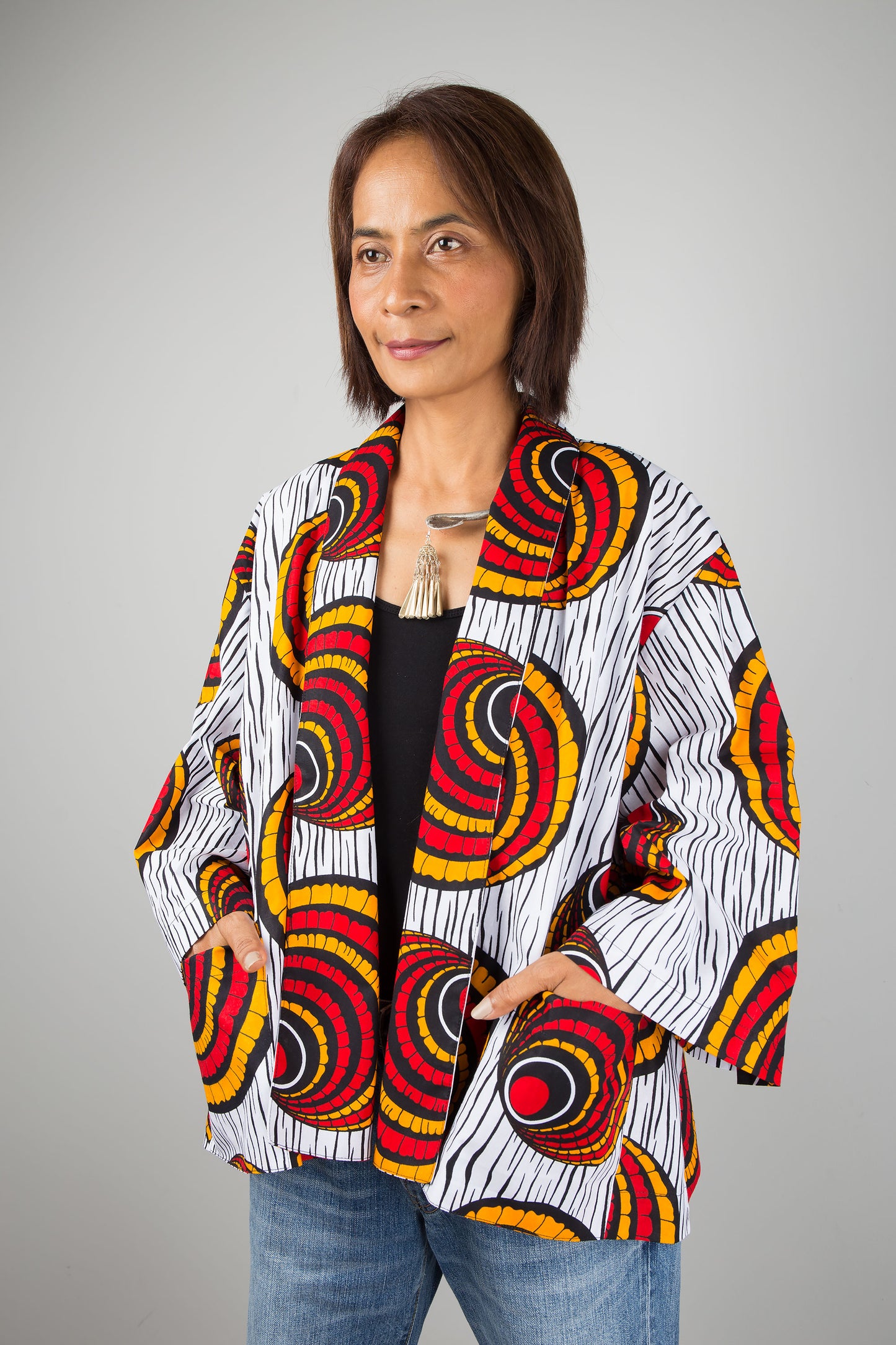 African kimono jacket top. Short jacket top in ankara fabric. Hands in pocket view