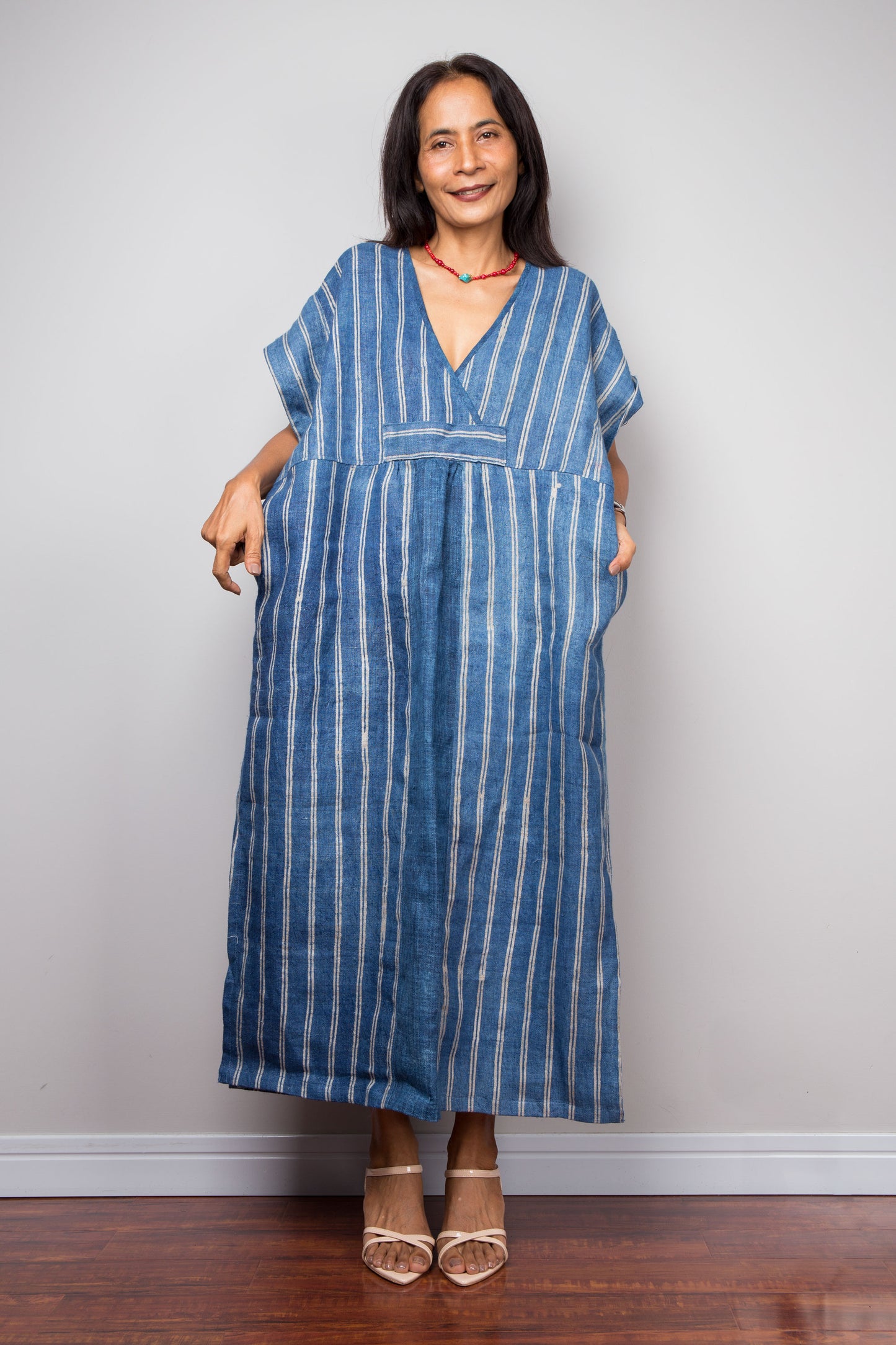 Woman wearing a blue striped dress against a plain background