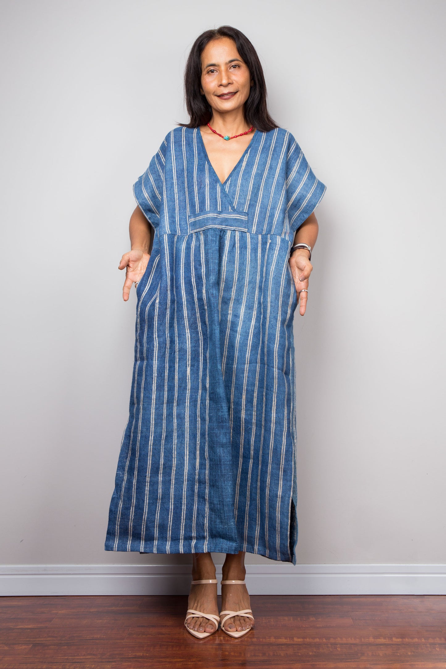 Nuichan wearing a blue striped caftan dress against a plain background. Handwoven hemp kaftan