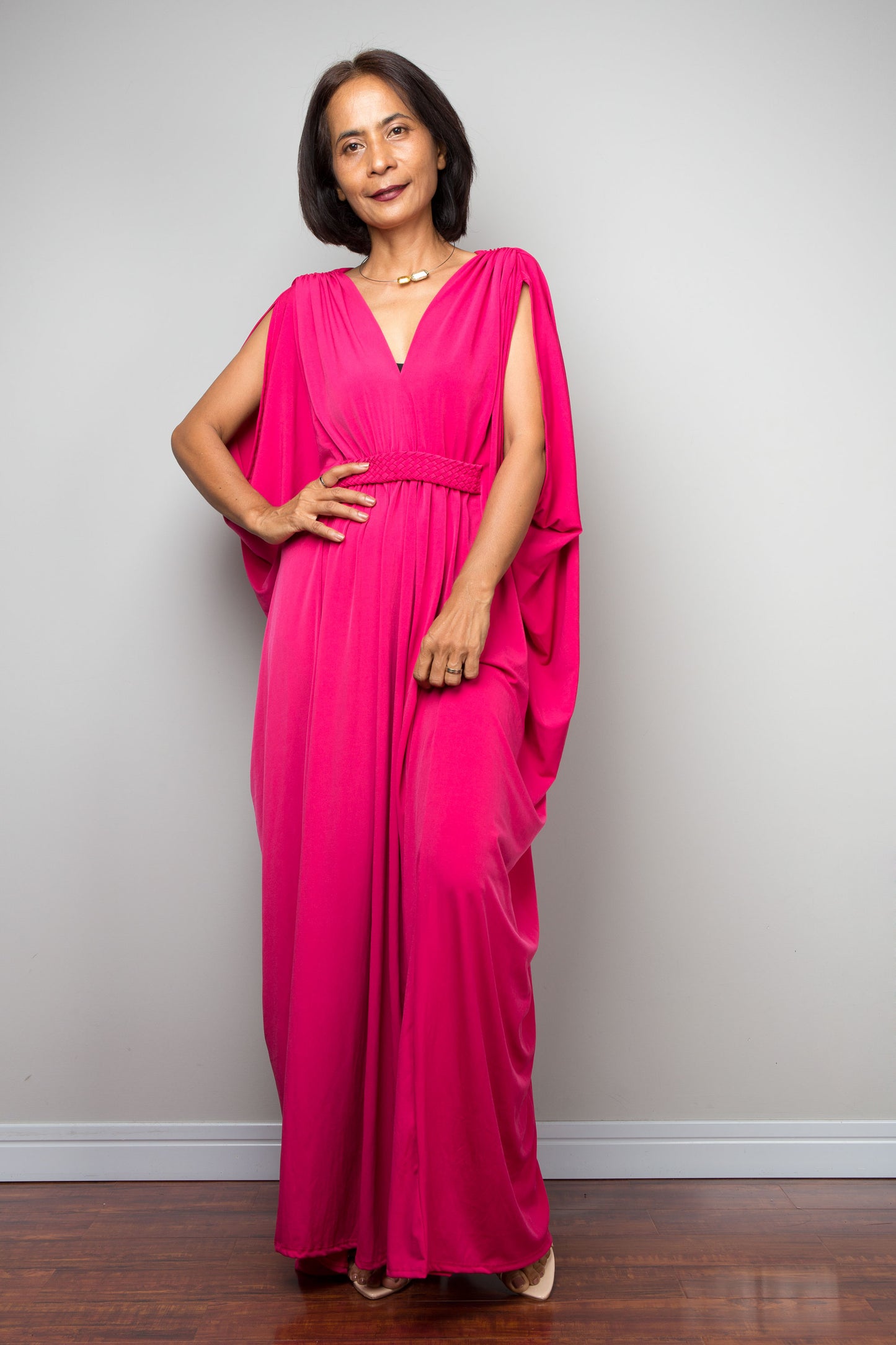 Woman wearing a bright pink dress against a plain background