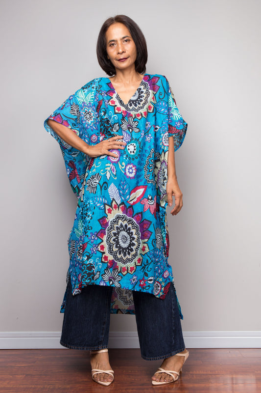Petite Woman wearing a colorful floral boho kaftan dress against a plain background