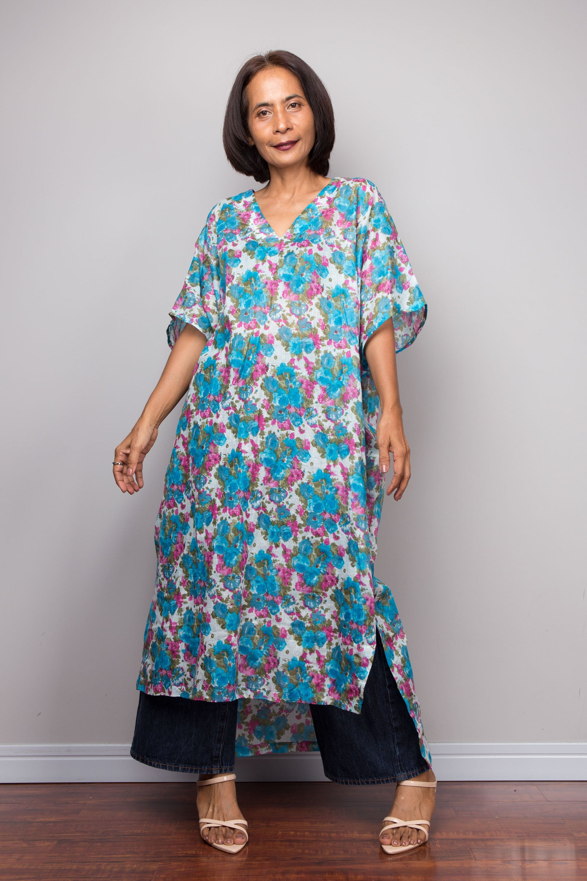 Petite Woman wearing a colorful floral cotton dress against a plain background