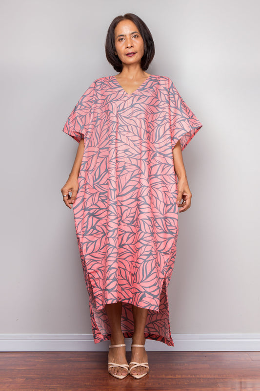 Petite Woman wearing a pink and grey patterned caftan dress against a plain background
