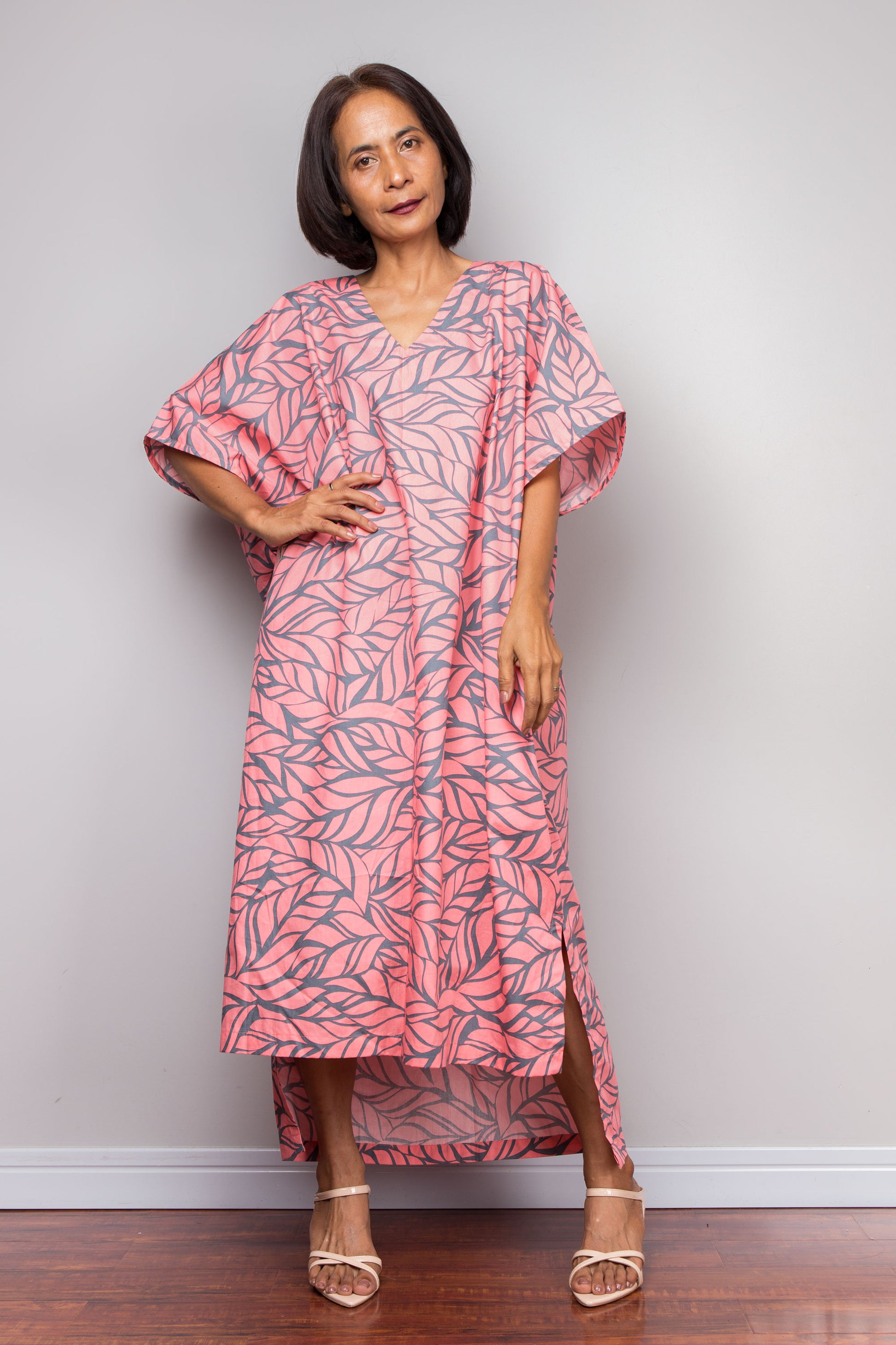 Petite Woman wearing a pink cotton caftan dress against a plain background