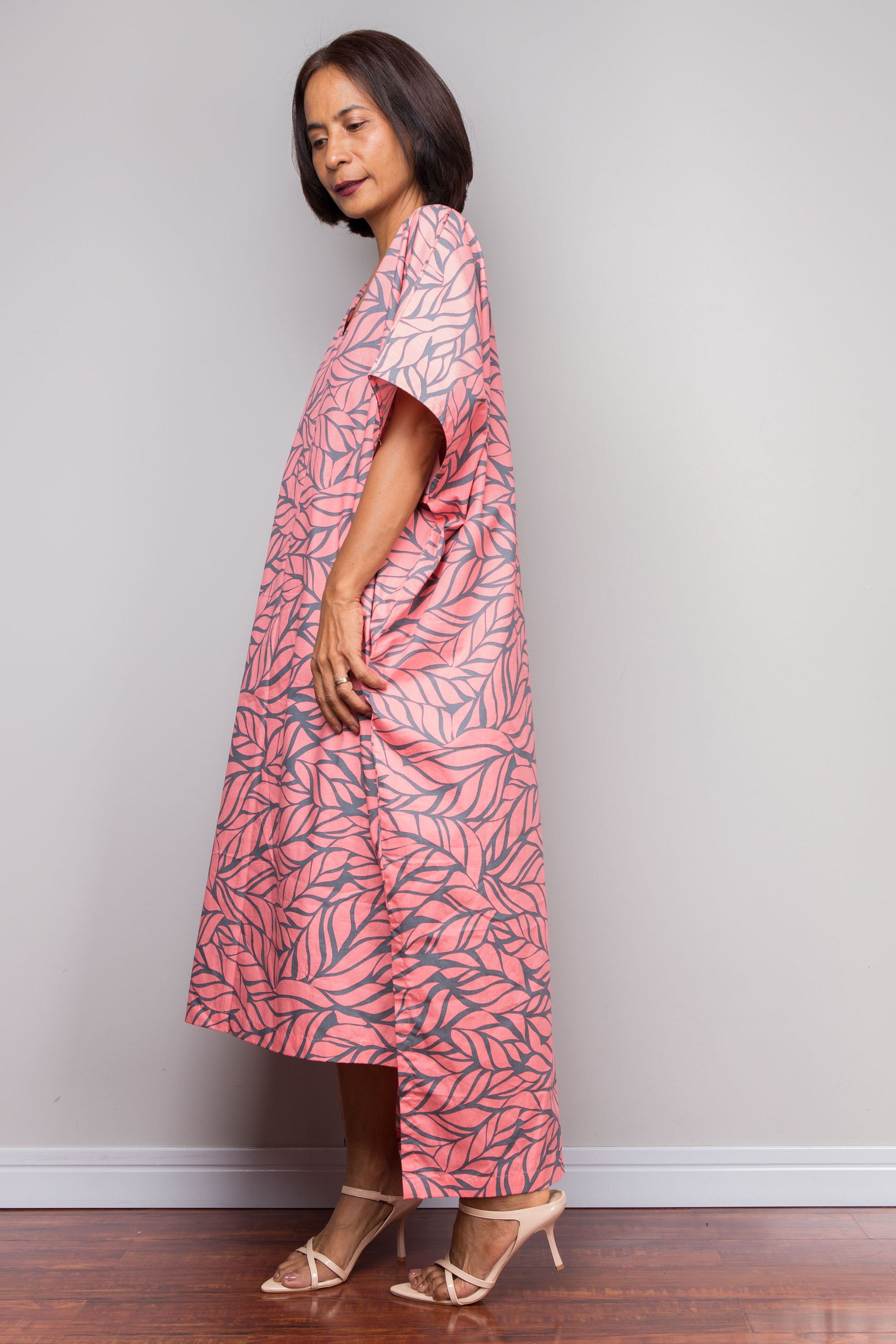 Petite Woman wearing a pink cotton kaftan dress against a plain background