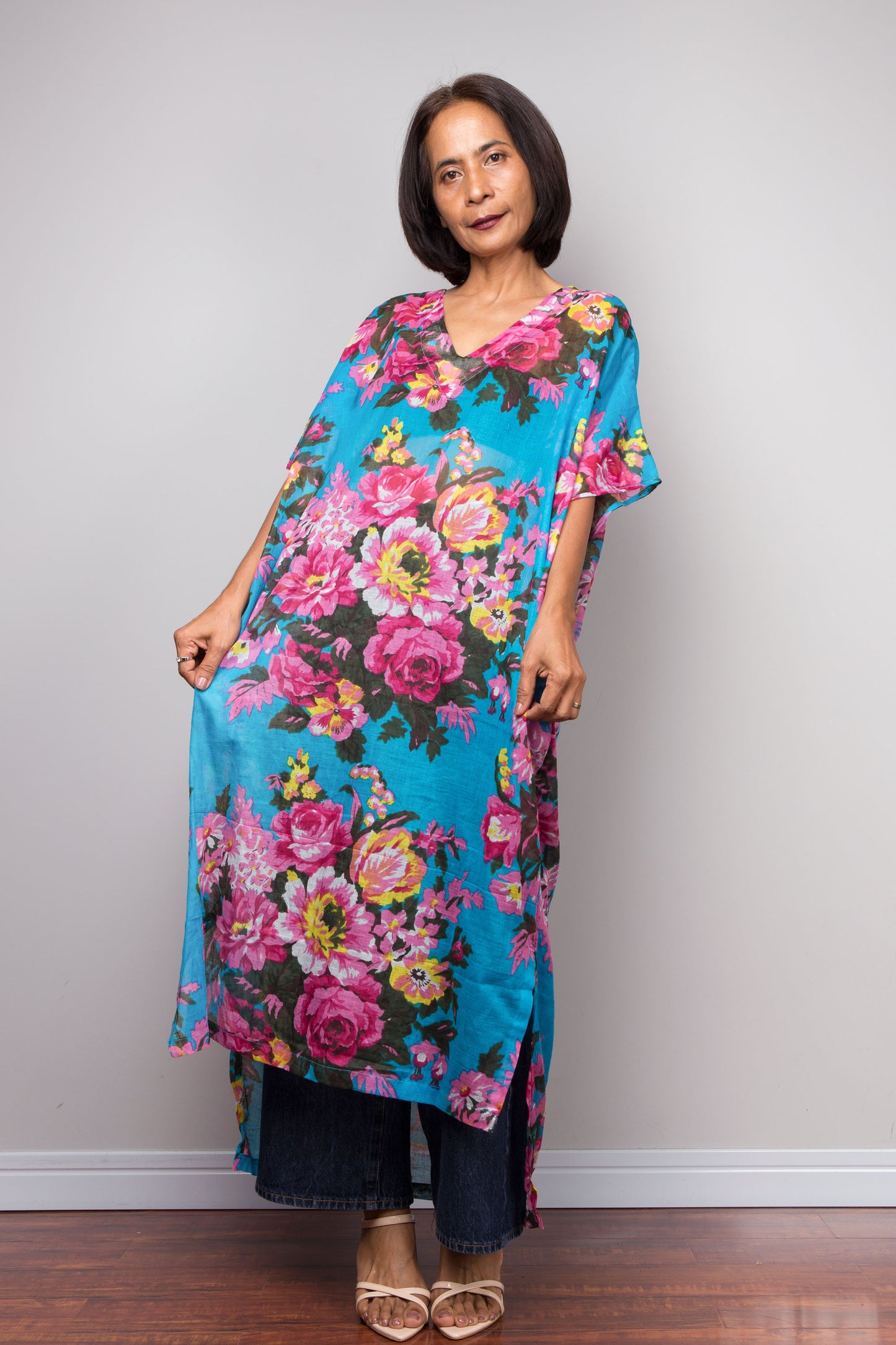 Petite Woman wearing a colorful floral caftan dress against a plain background