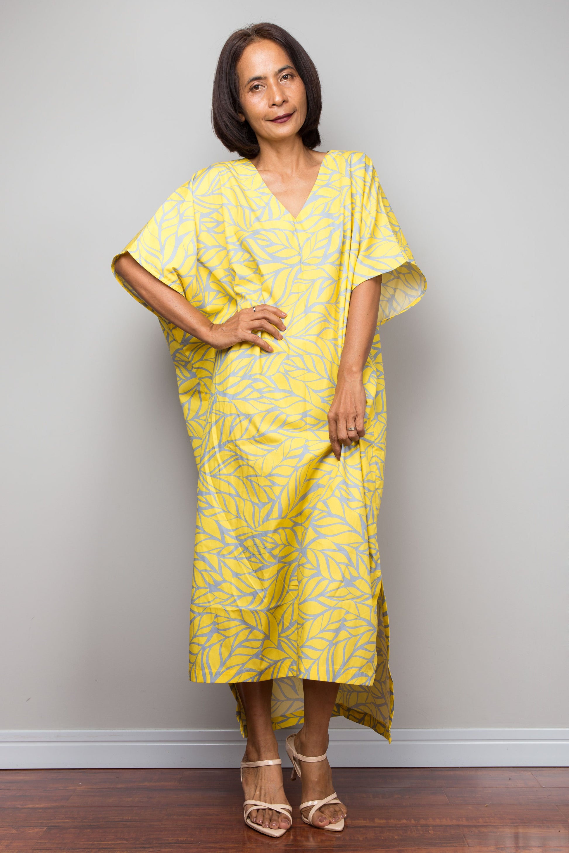 Woman wearing a yellow caftan dress with a pattern