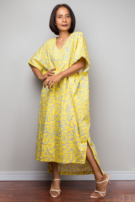 Woman wearing a yellow patterned cotton caftan dress for petite women against a plain background