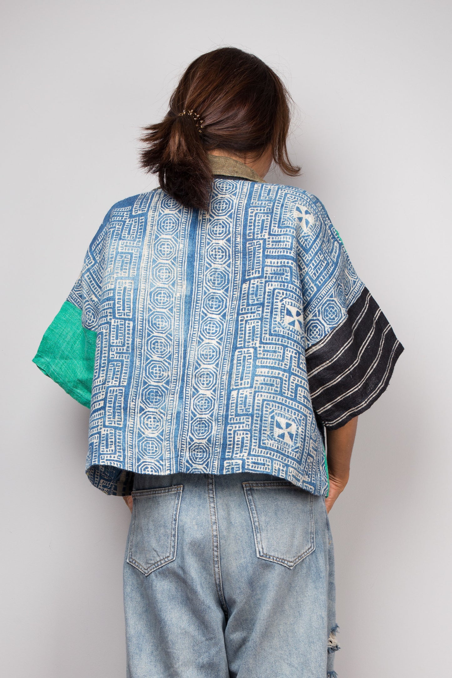 Patchwork polo shirt pullover top made from various handwoven hemp fabrics. Back view. Back is natural indigo batik drawing by hill tribes