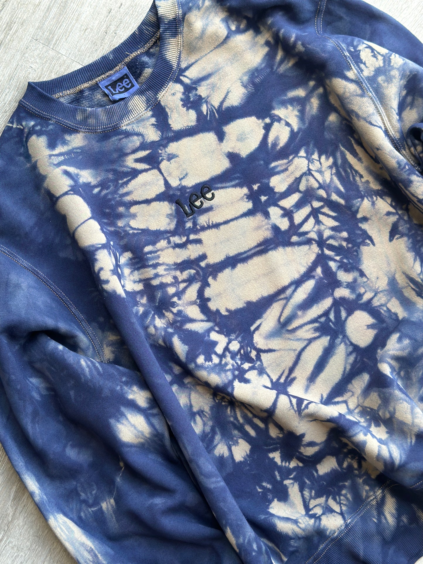 Blue and white tie-dye sweatshirt on a flat surface