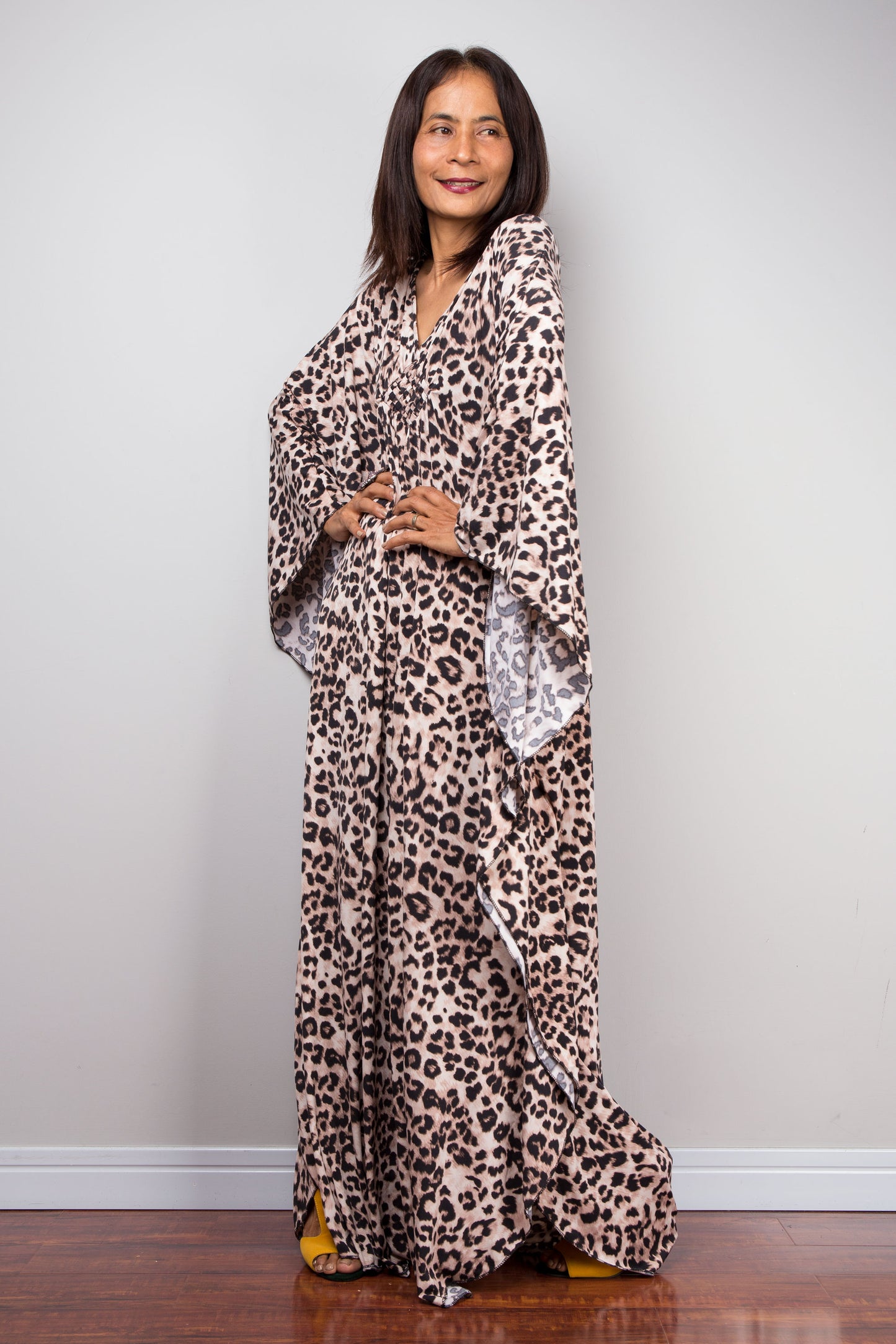 Leopard print kaftan dress in ITY polyester. The dress features a deep V-neck with a diamond-shaped detail at the chest, three-quarter sleeves, and a flowing silhouette, perfect for summer events.