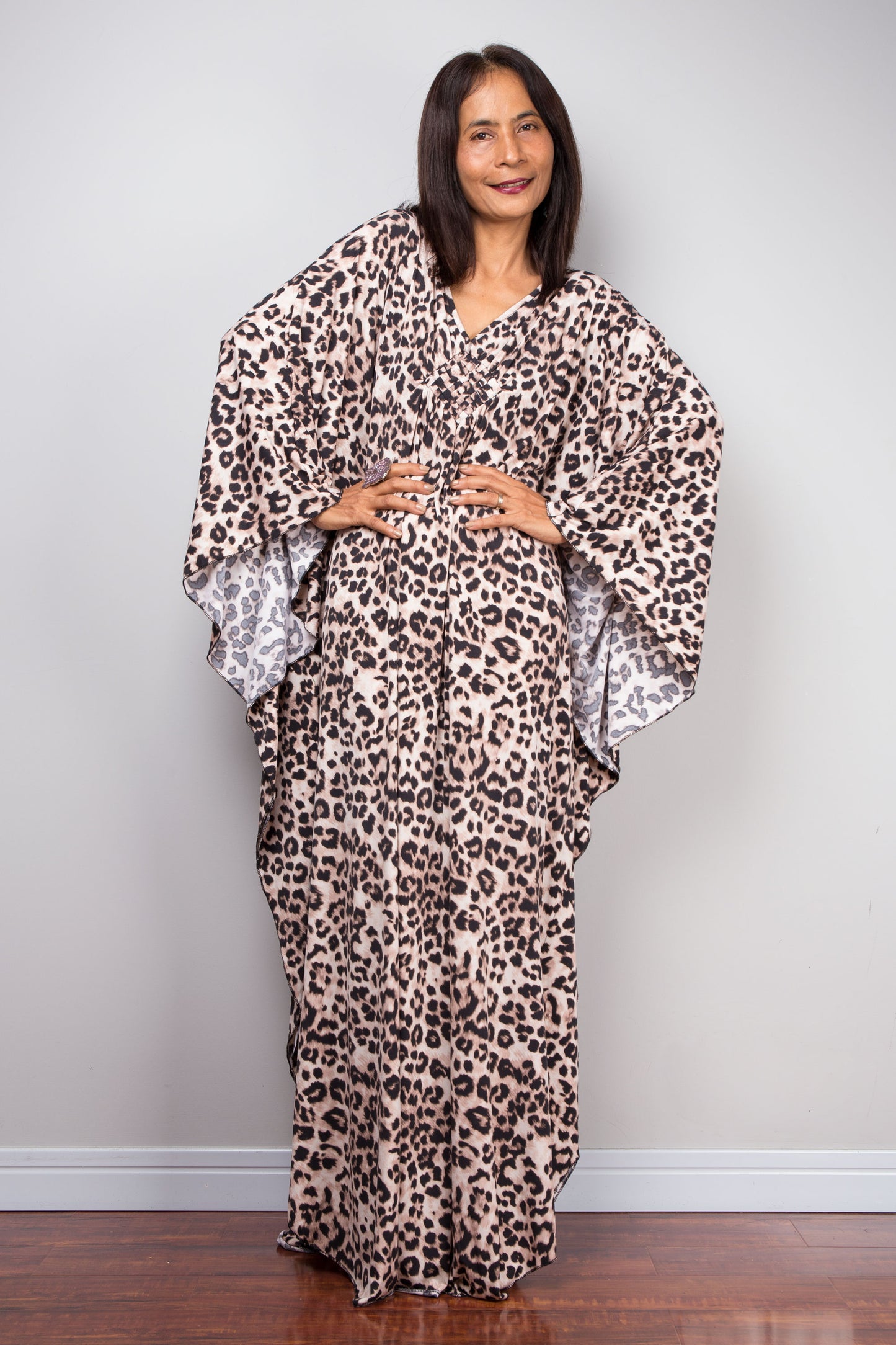 Leopard kaftan dress by Nuichan. The dress’s deep V-neckline with a diamond-shaped detail, three-quarter sleeves, and full length make it a perfect choice for tropical summer fashion.