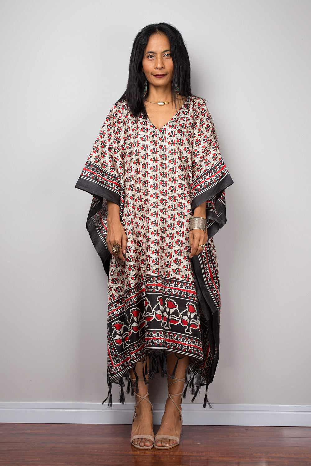 Woman wearing a patterned caftan dress with a plain background