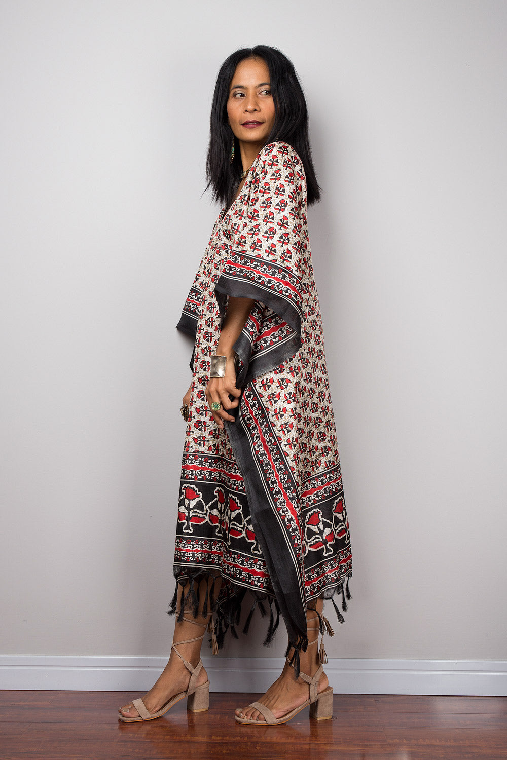 Woman wearing a patterned kaftan dress for petite against a plain background