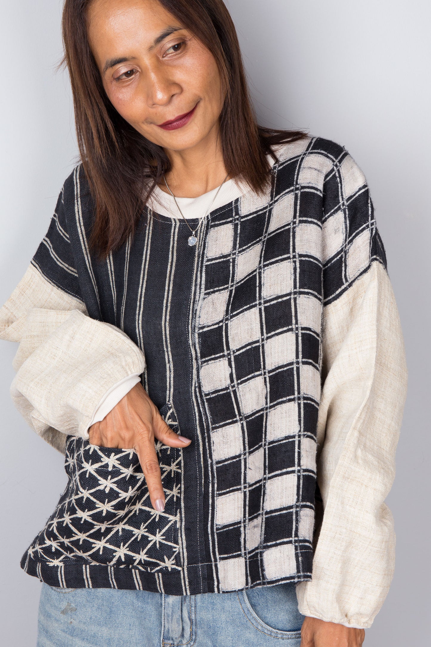Handwoven hemp sweater with combination of a checkered and striped pattern. Two tone in black and off white.