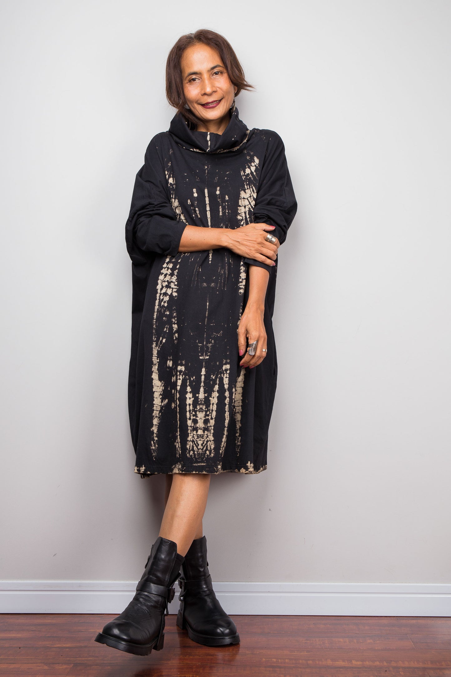 Oversized Nuichan reverse tie dye tunic dress featuring a cowl neck and vertical abstract sand and black patterns. Rolled up sleeve look.