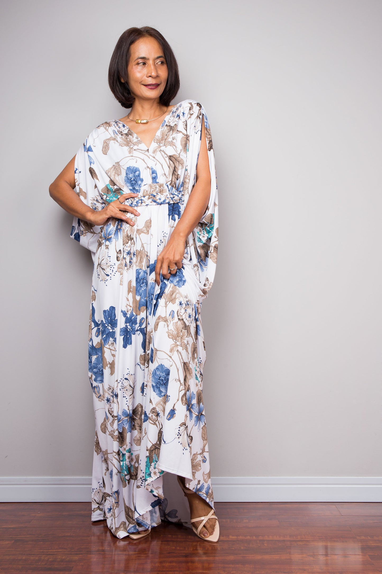 Woman wearing a floral caftan against a plain background