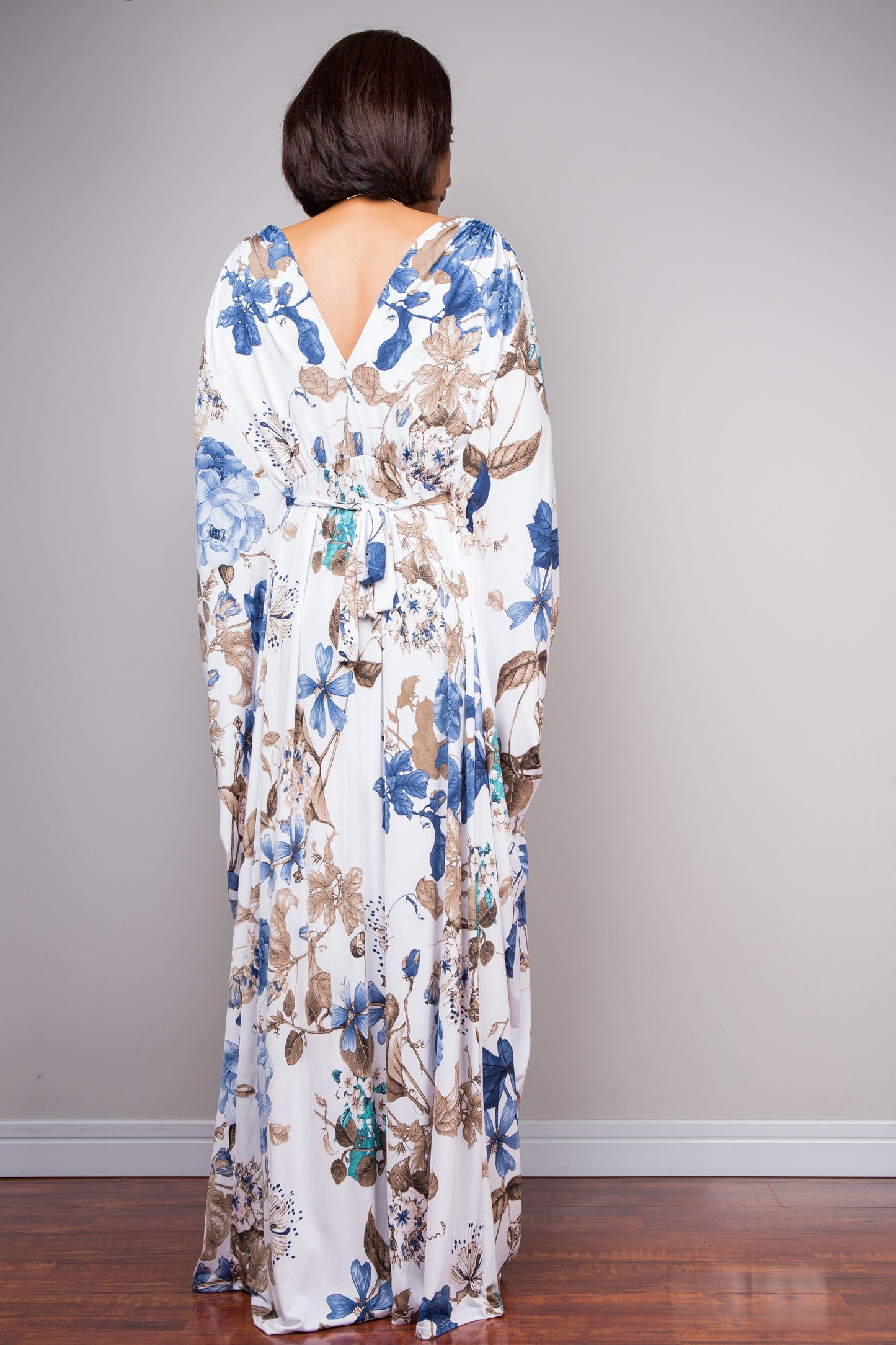 Full-length white maxi dress with blue and brown botanical design.
