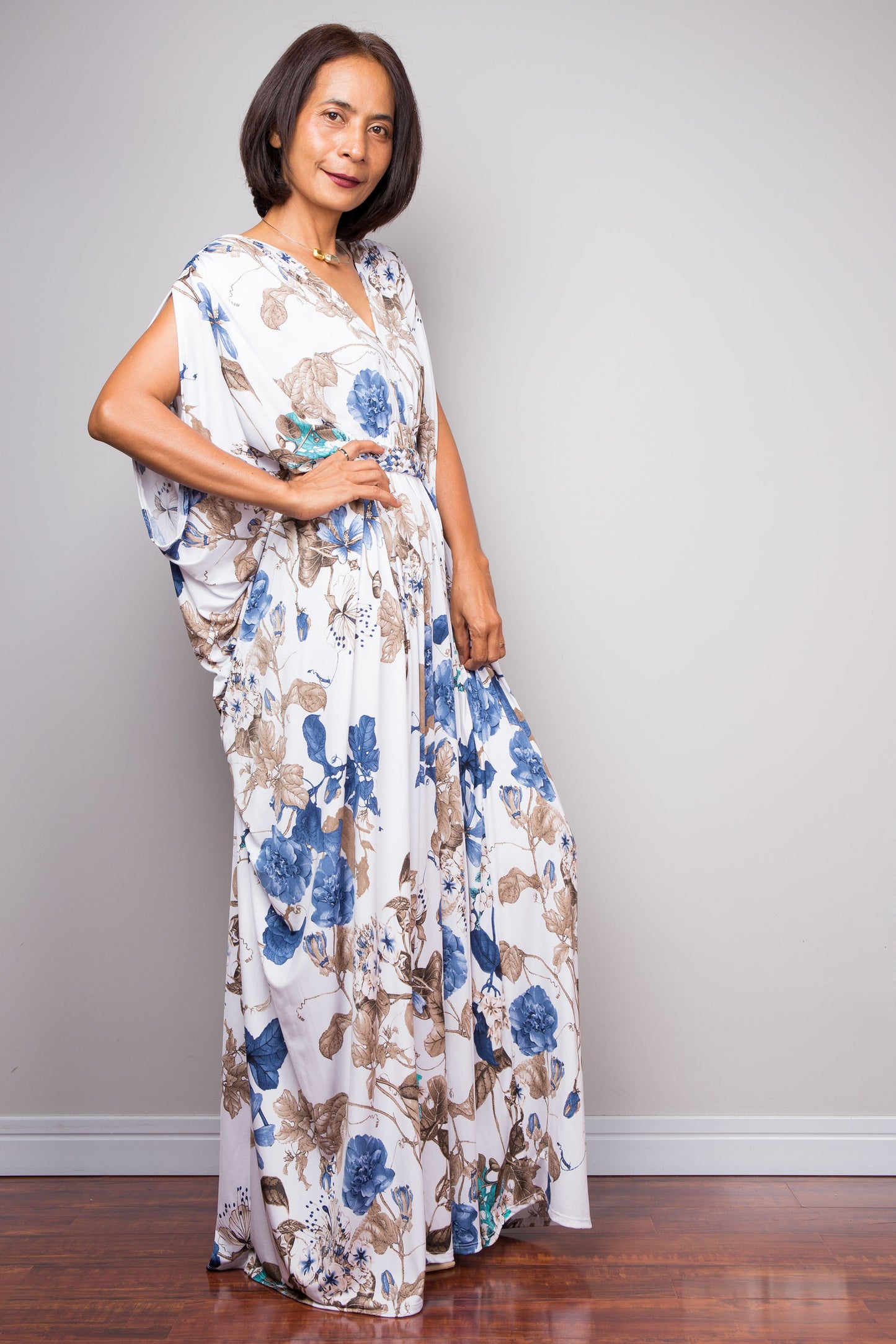 Woman wearing a floral dress against a plain background