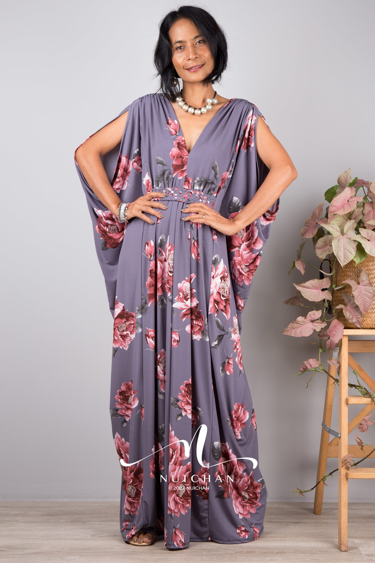 Model wearing a grey kaftan with floral print. Petite dress with v neck