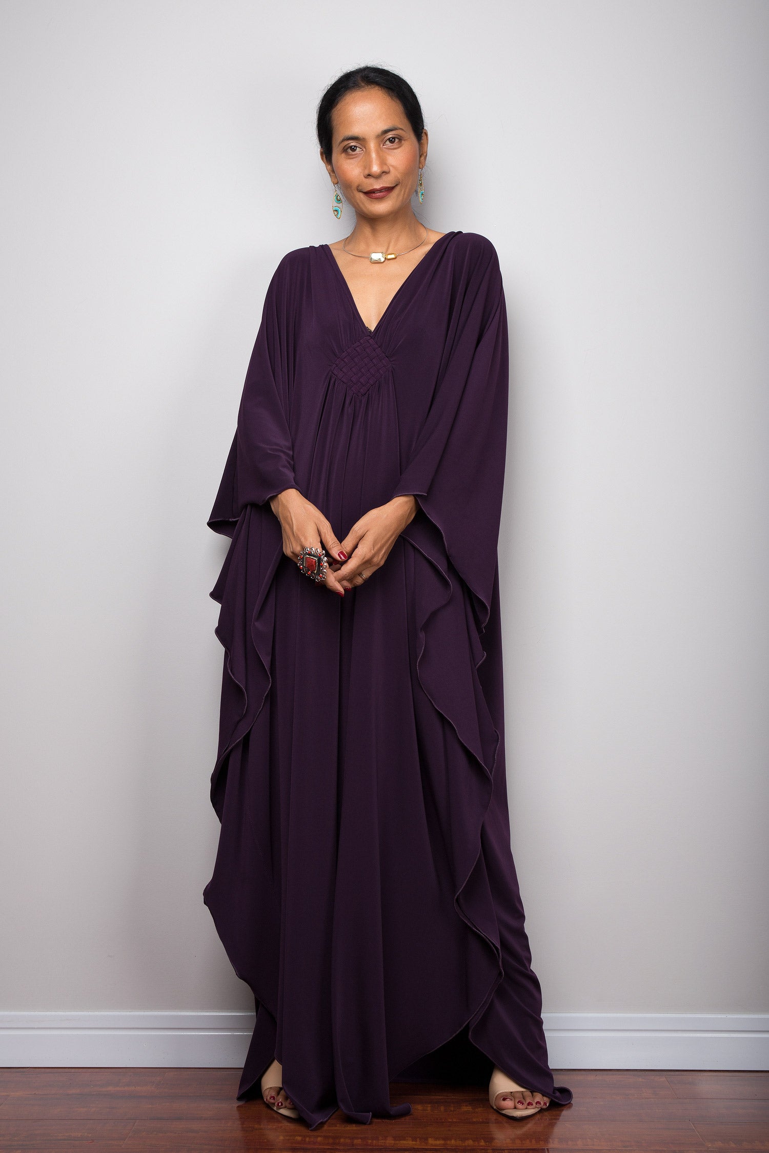 Dark purple caftan dress with plunging neckline and batwing sleeves.