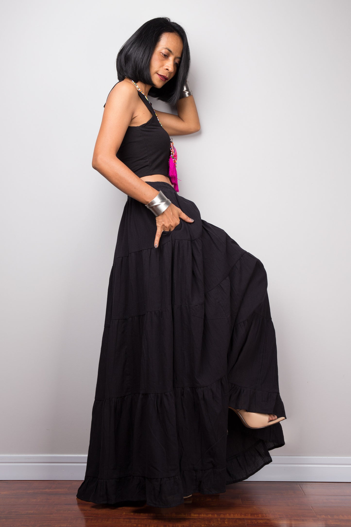 Black tiered maxi skirt by Nuichan. Pocket on the side.