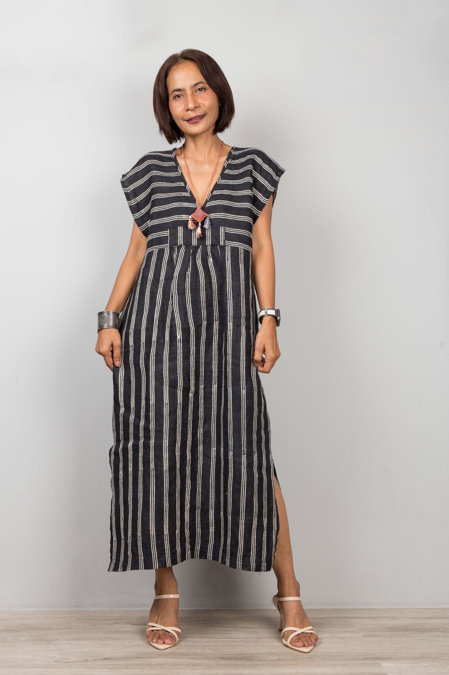 Woman wearing a black and white striped caftan against a plain background