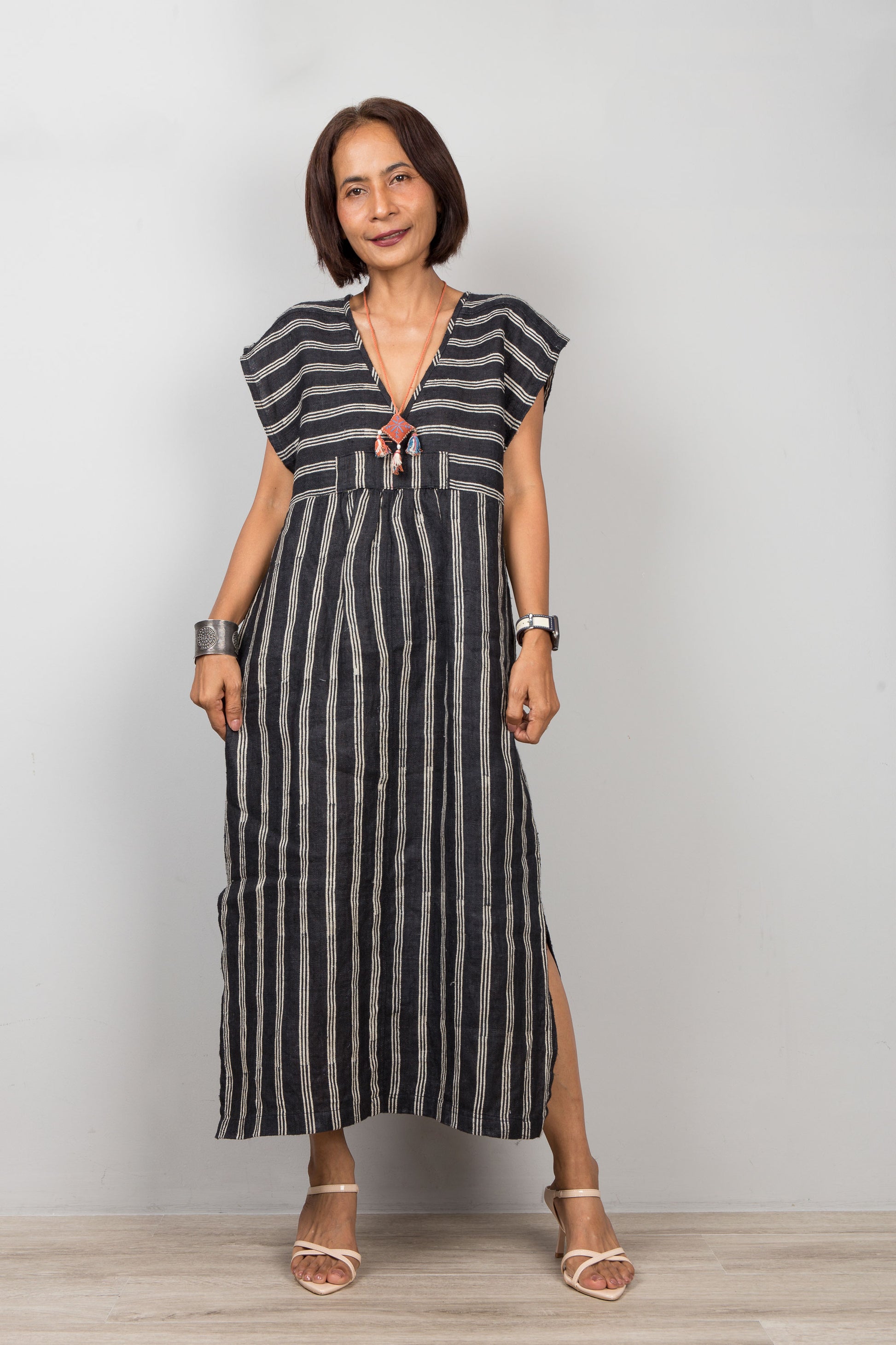 Woman wearing a black and white striped caftan against a plain background