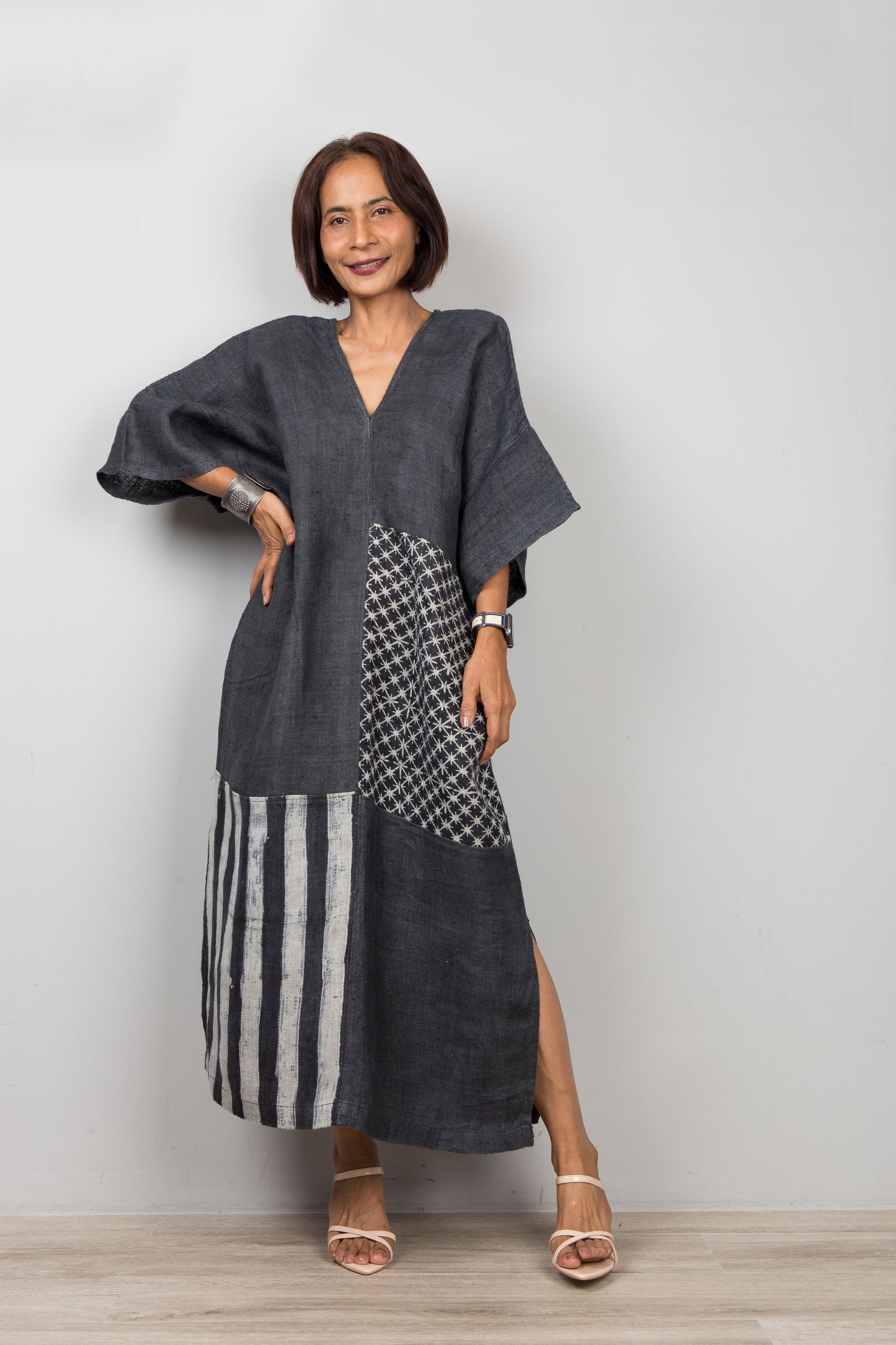 Woman wearing a black patchwork hemp dress with a plain background