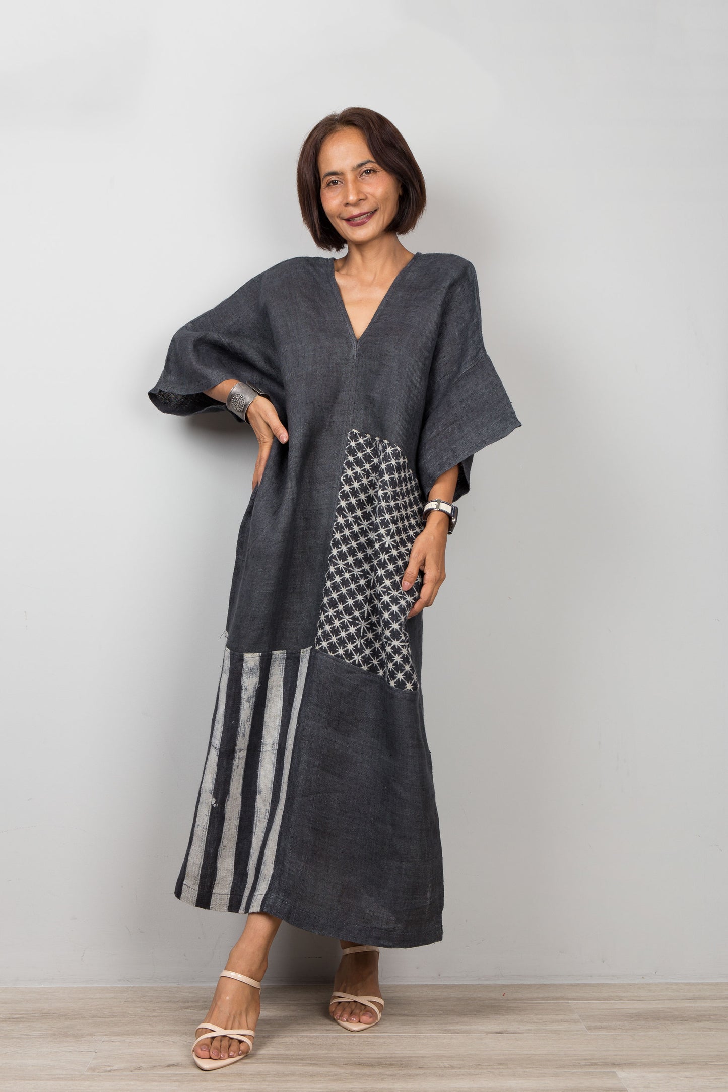 Woman wearing a black kaftan dress with a patterned section 