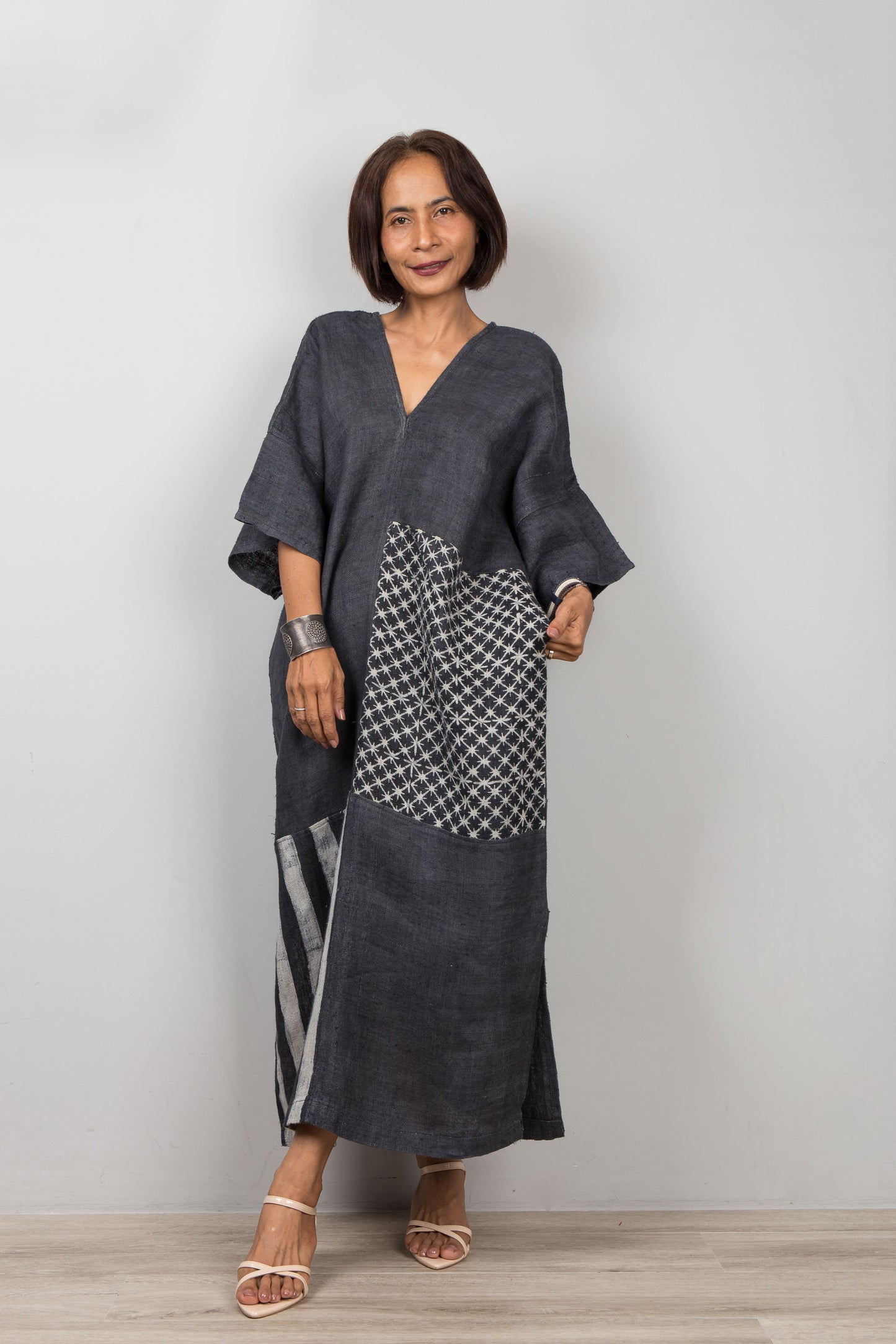 Woman wearing a black patchwork kaftan with a patterned section 