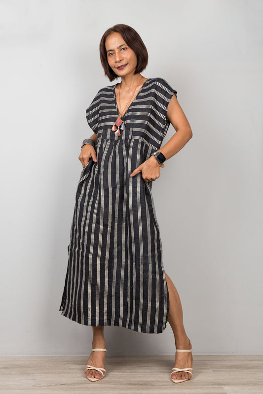 Woman wearing a black and white striped kaftan dress against a plain background