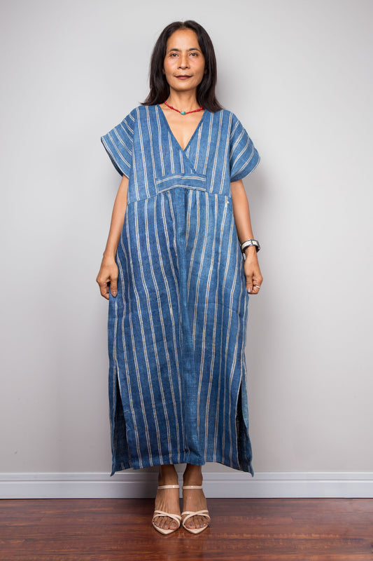 Woman wearing a blue striped hemp kaftan dress against a plain background.  Nuichan handwoven hemp collection