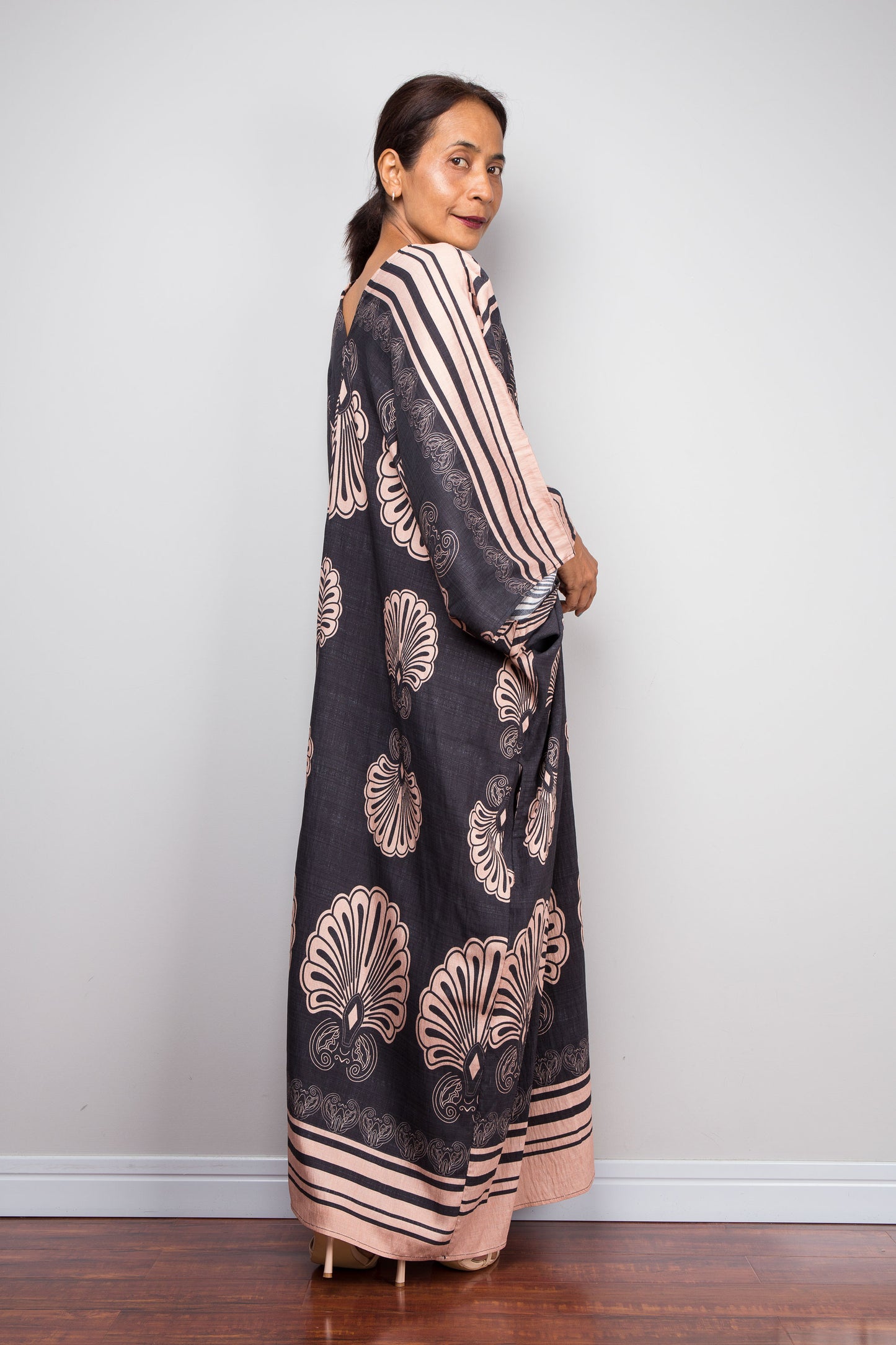 Three quarter back shot of a model in the Nuichan charcoal and blush batwing kaftan dress 