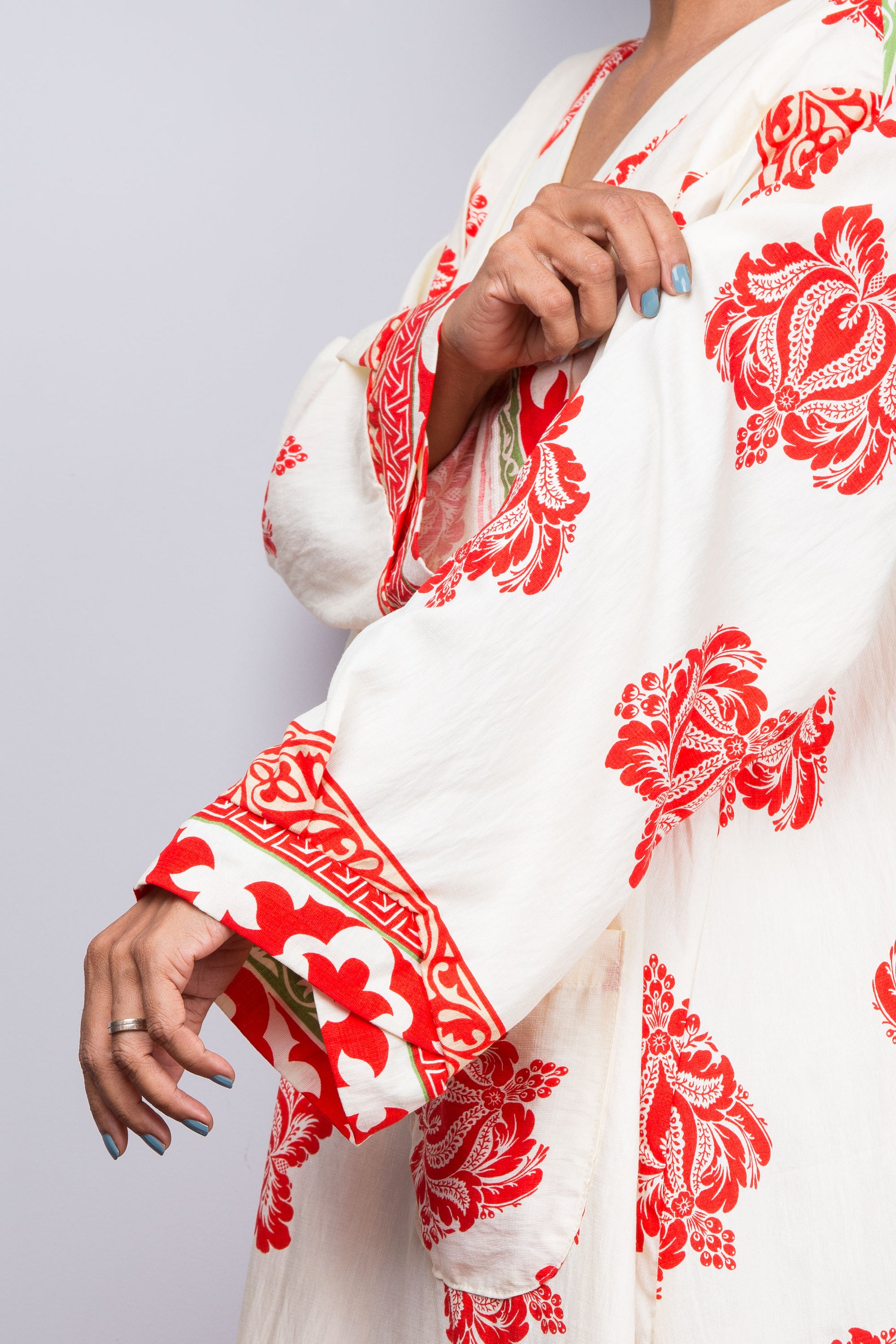 White garment with red floral patterns on a plain background