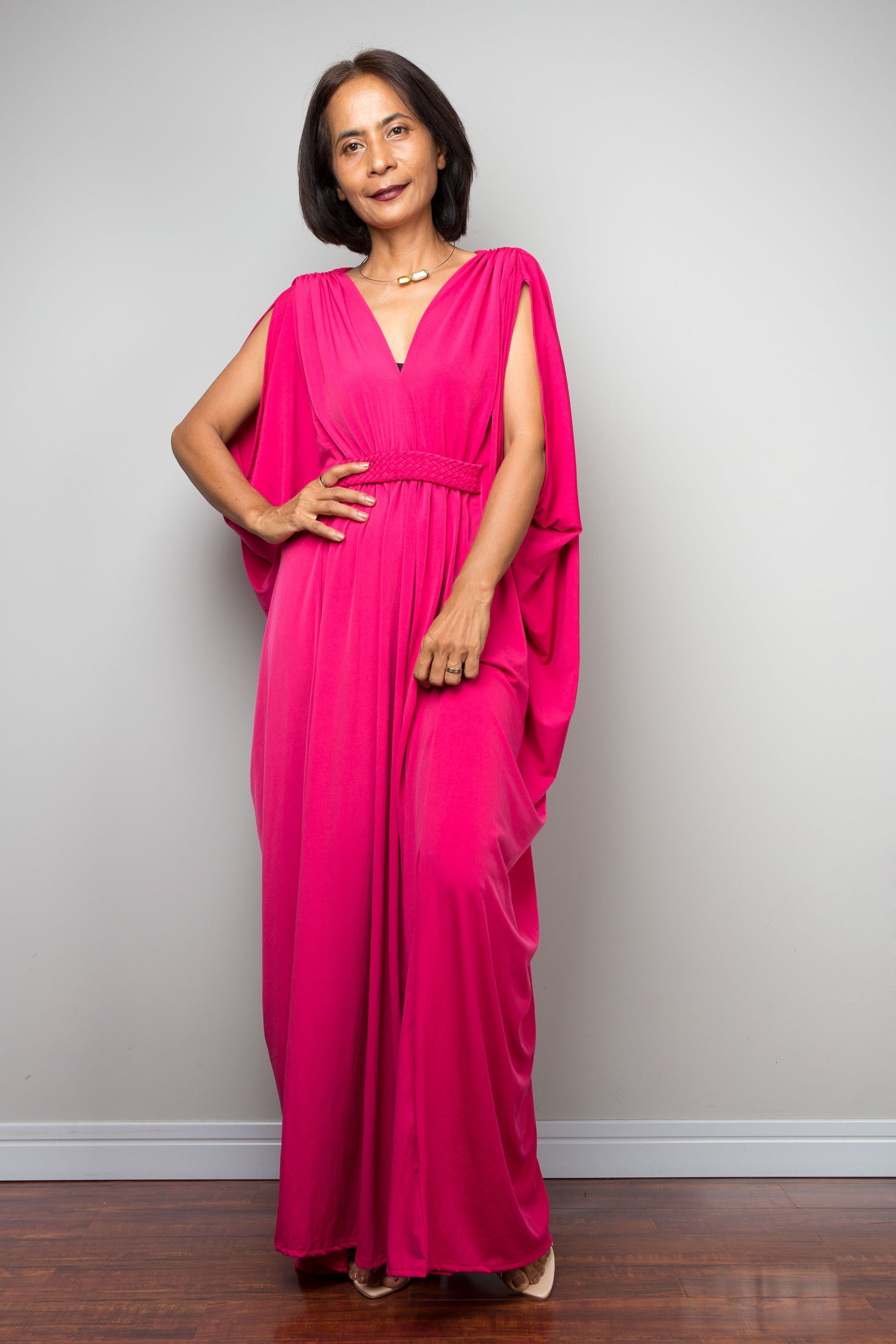 Woman wearing a bright pink dress against a plain background
