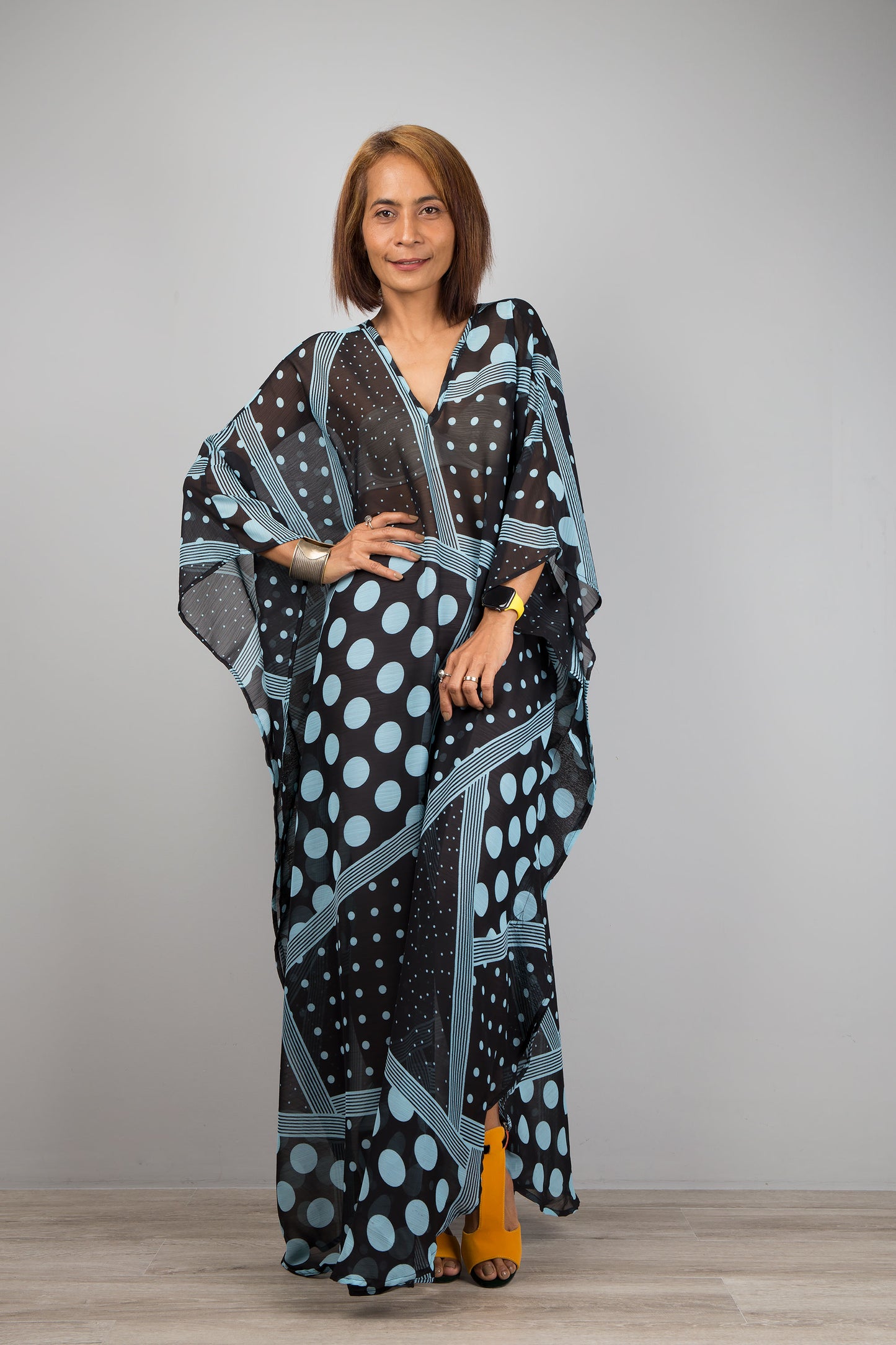 Light blue polka dot kaftan dress by Nuichan.  Caftan with small v neck in a sheer chiffon fabric. Front view