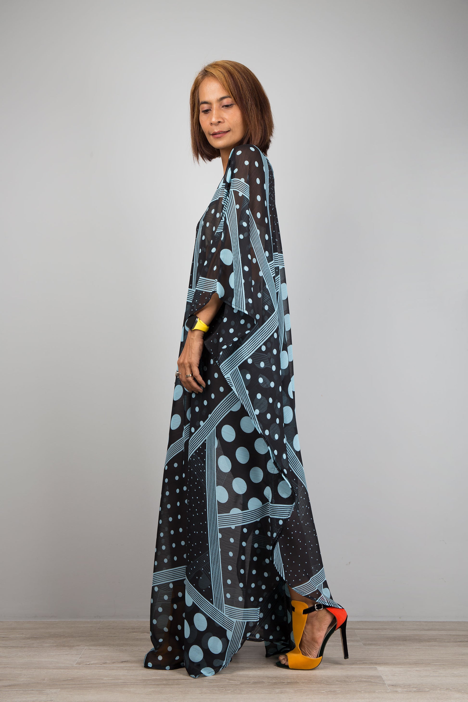 Light blue polka dot kaftan dress by Nuichan.  Caftan with small v neck in a sheer chiffon fabric. Side view.