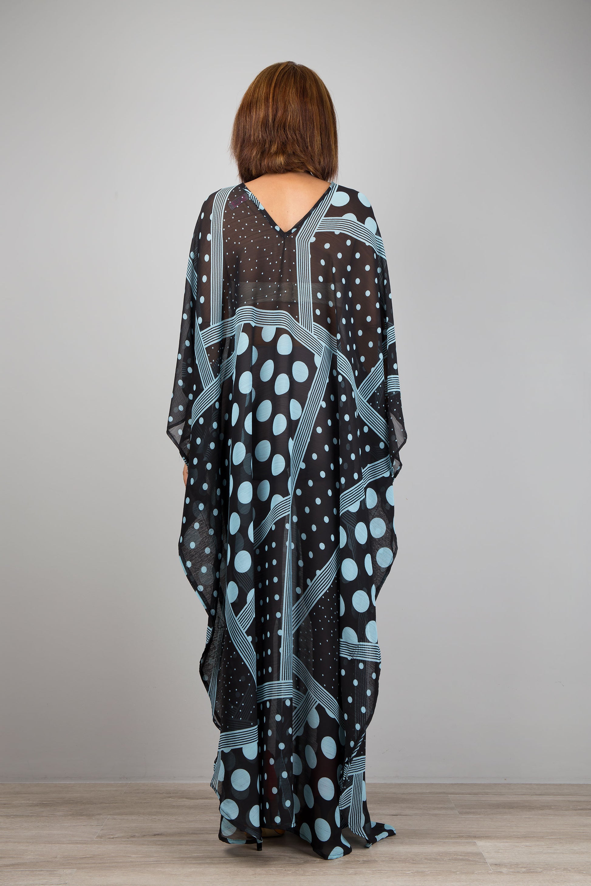 Light blue polka dot kaftan dress by Nuichan.  Caftan with small v neck in a sheer chiffon fabric. Back view