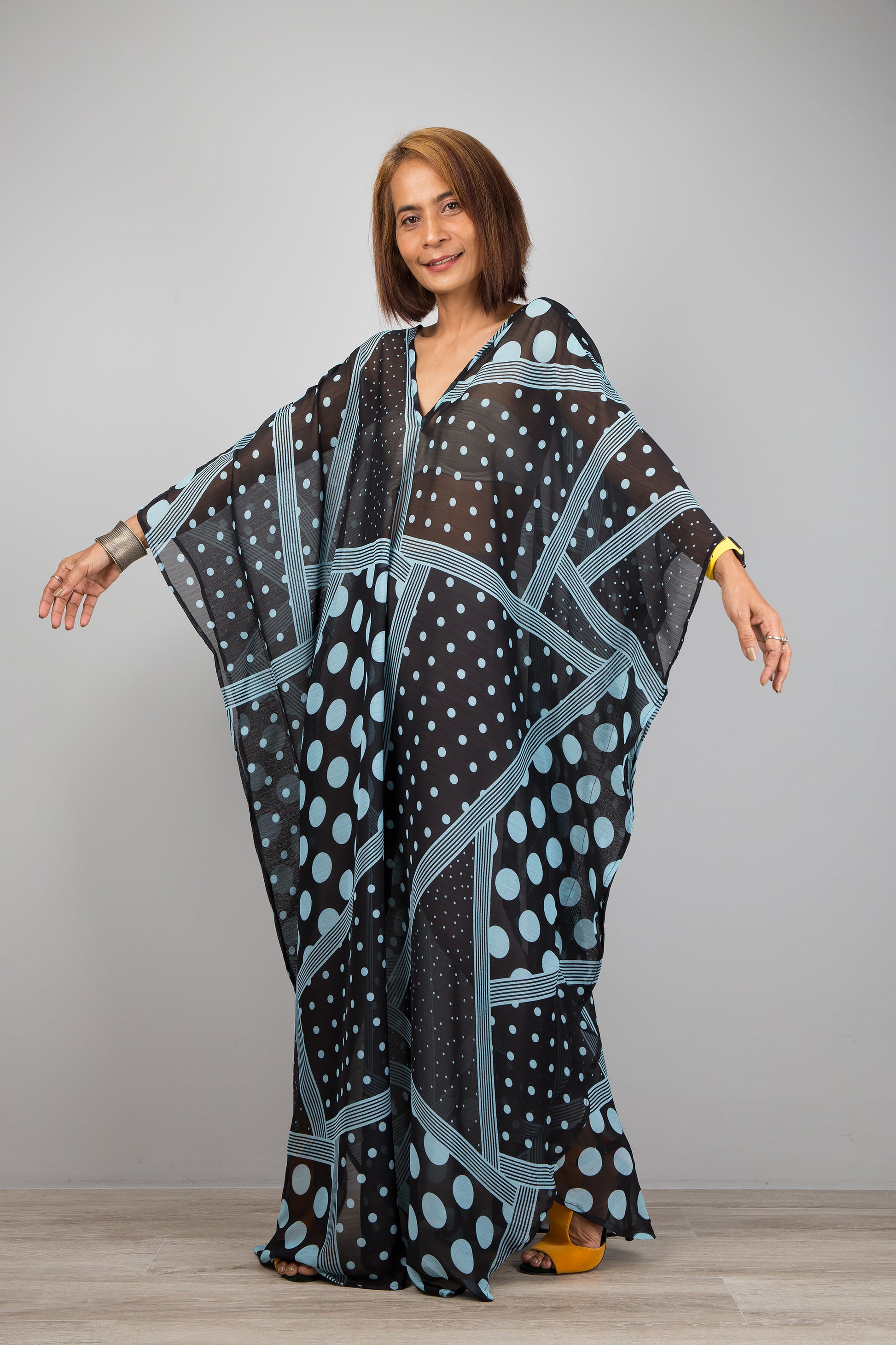 Light blue polka dot kaftan dress by Nuichan.  Caftan with small v neck in a sheer chiffon fabric. Loose fit design.