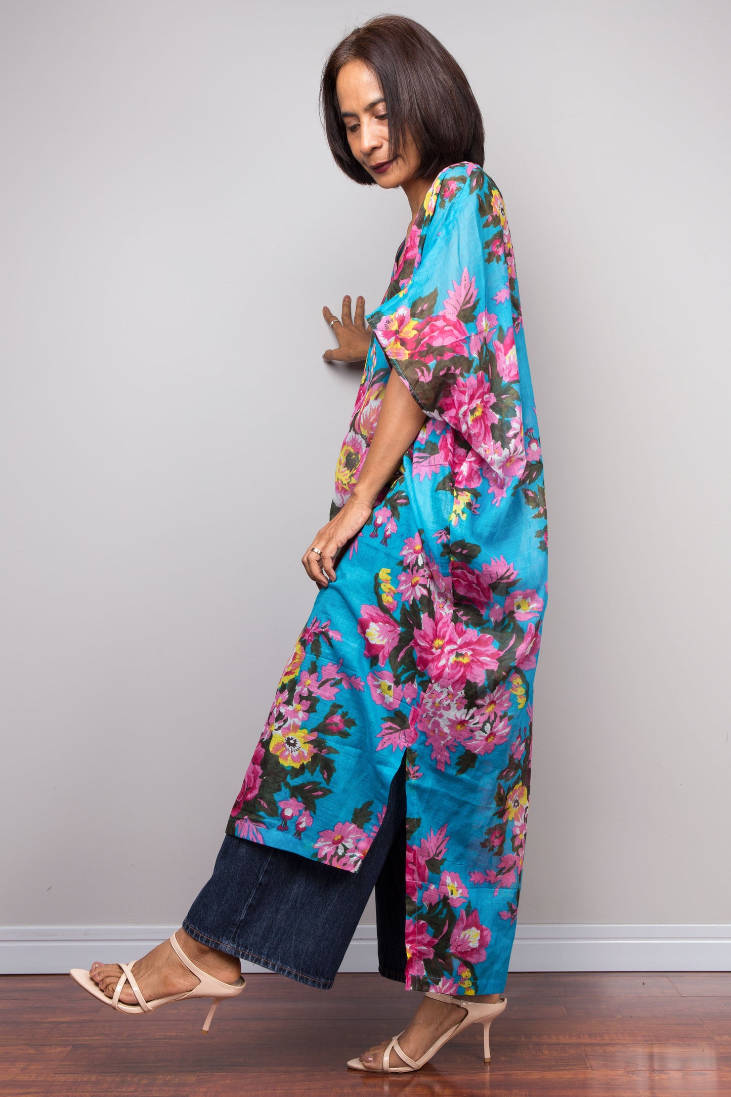 Woman wearing a blue floral caftan against a plain background