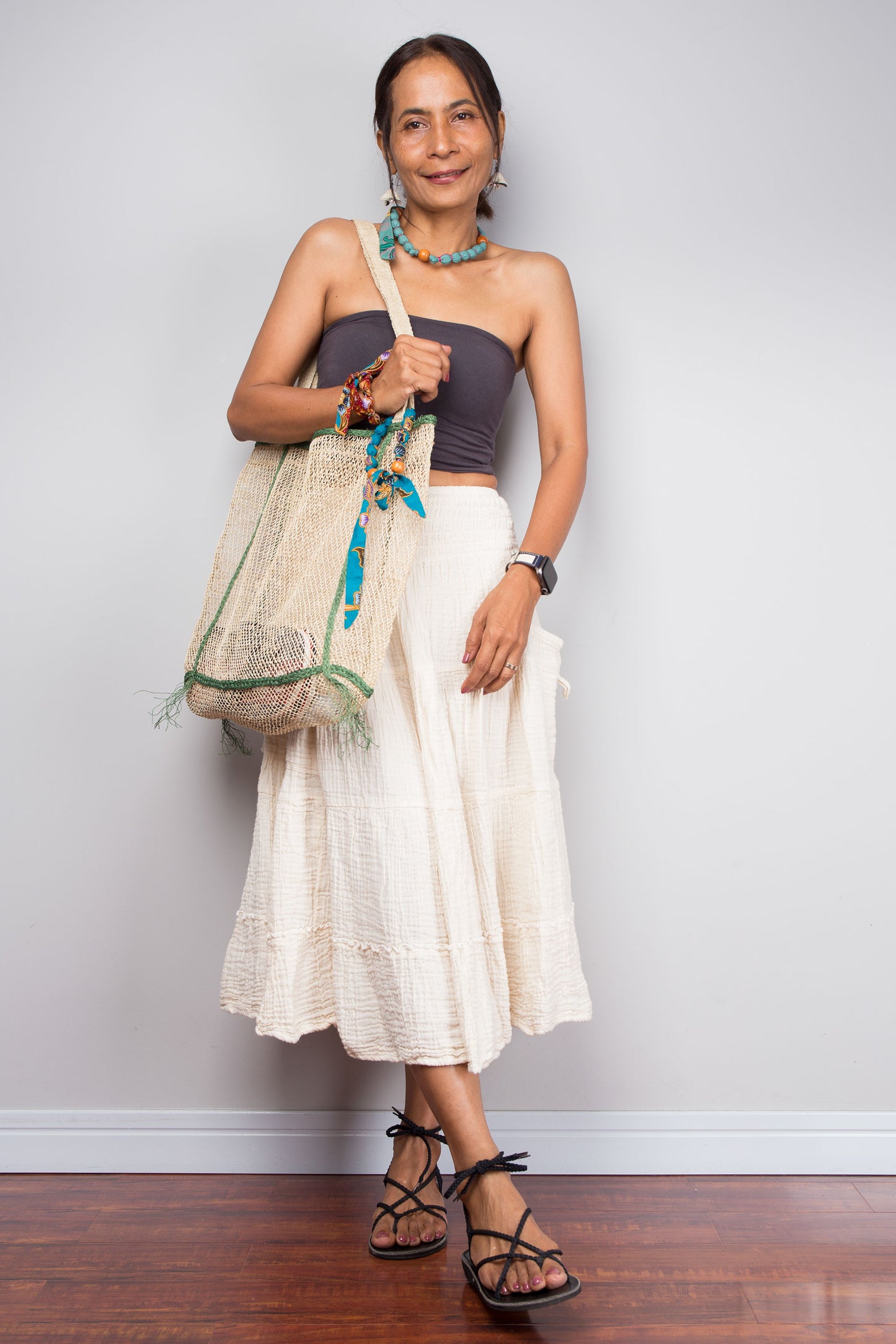 Woman holding a decorative bag against a plain background