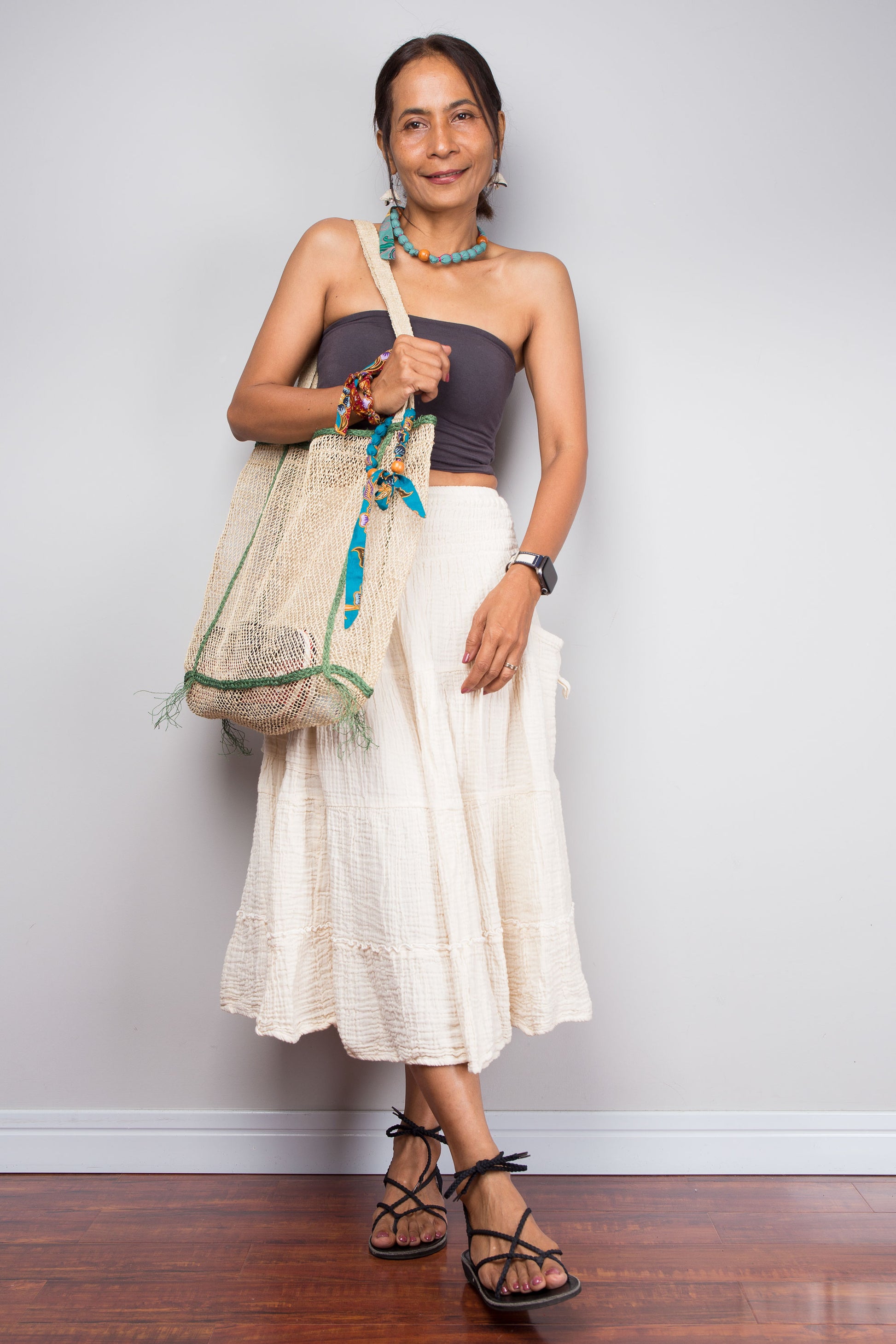 Woman holding a decorative bag against a plain background