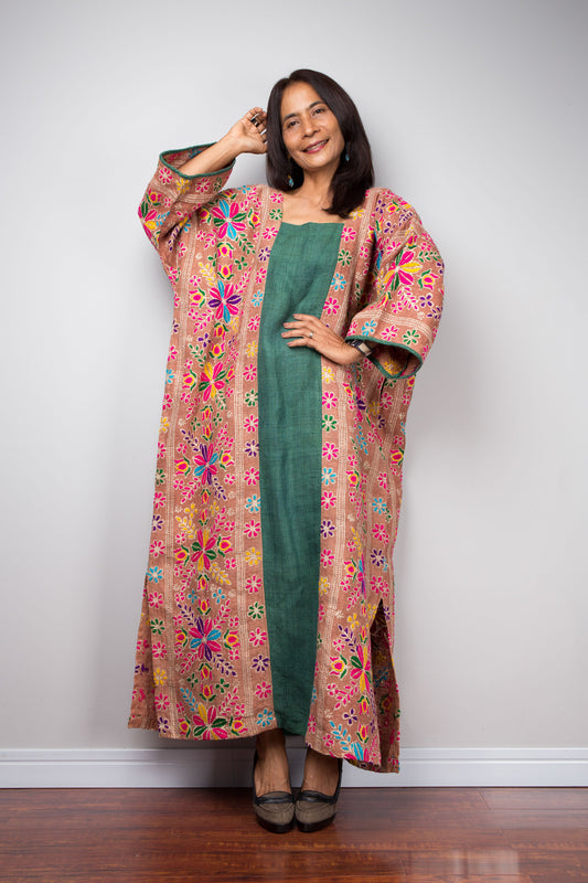 Woman wearing handwoven hemp kaftan with bright floral embroidery