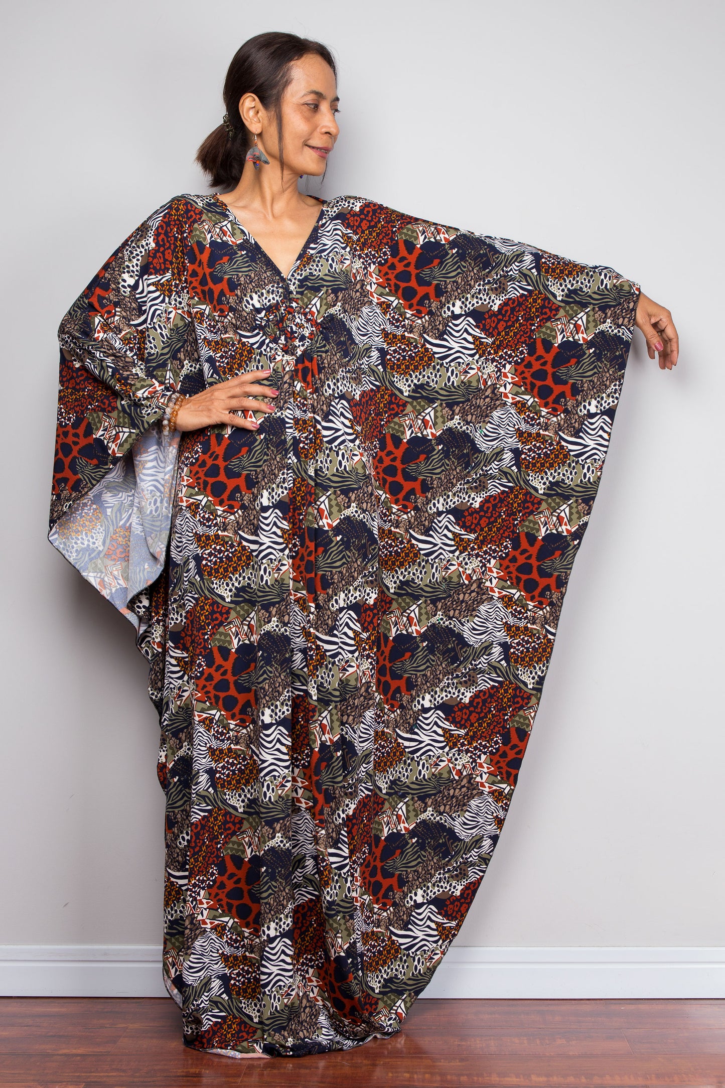 Woman wearing a floral patterned kaftan by Nuichan against a plain background