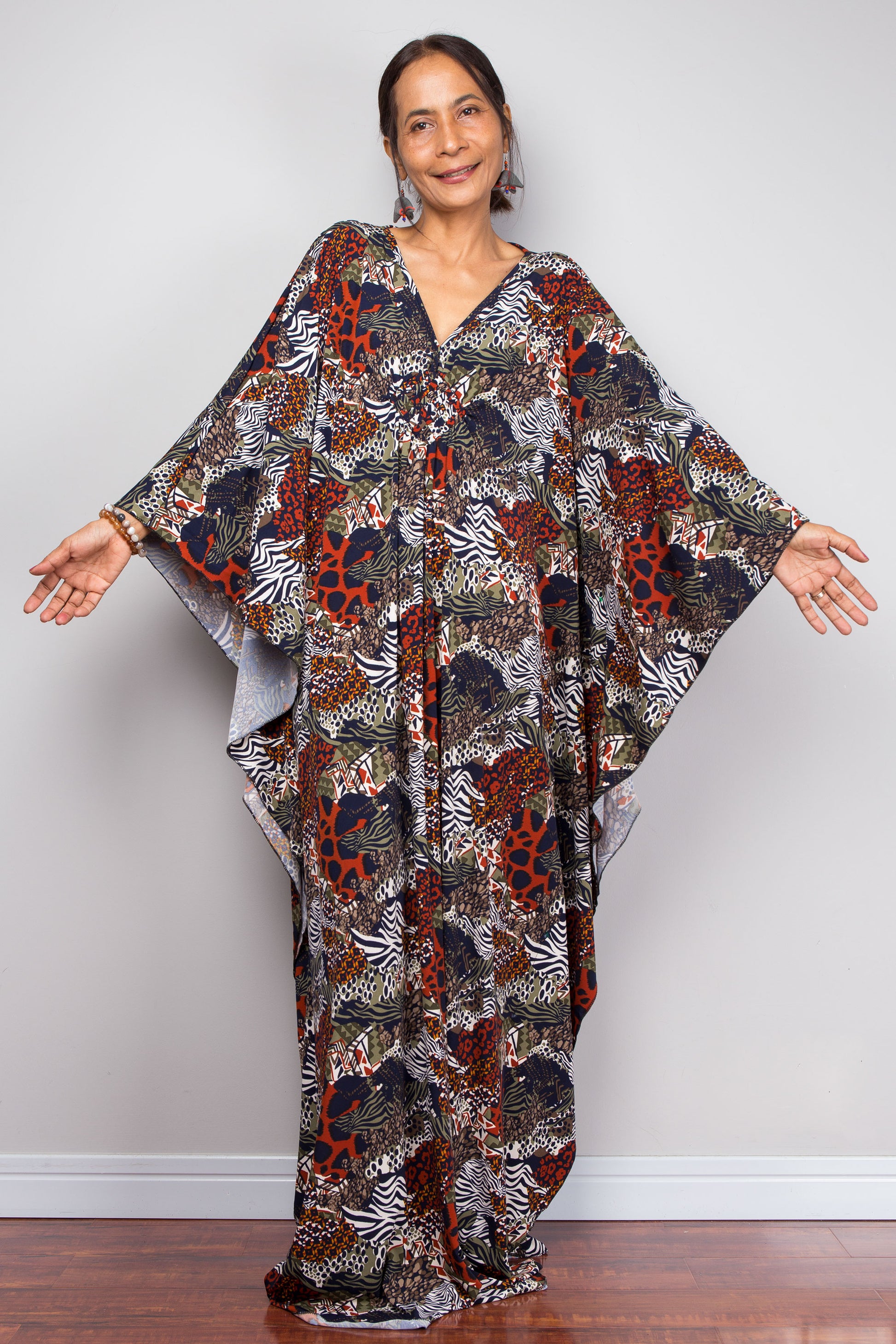 Woman wearing a patterned caftan against a plain background