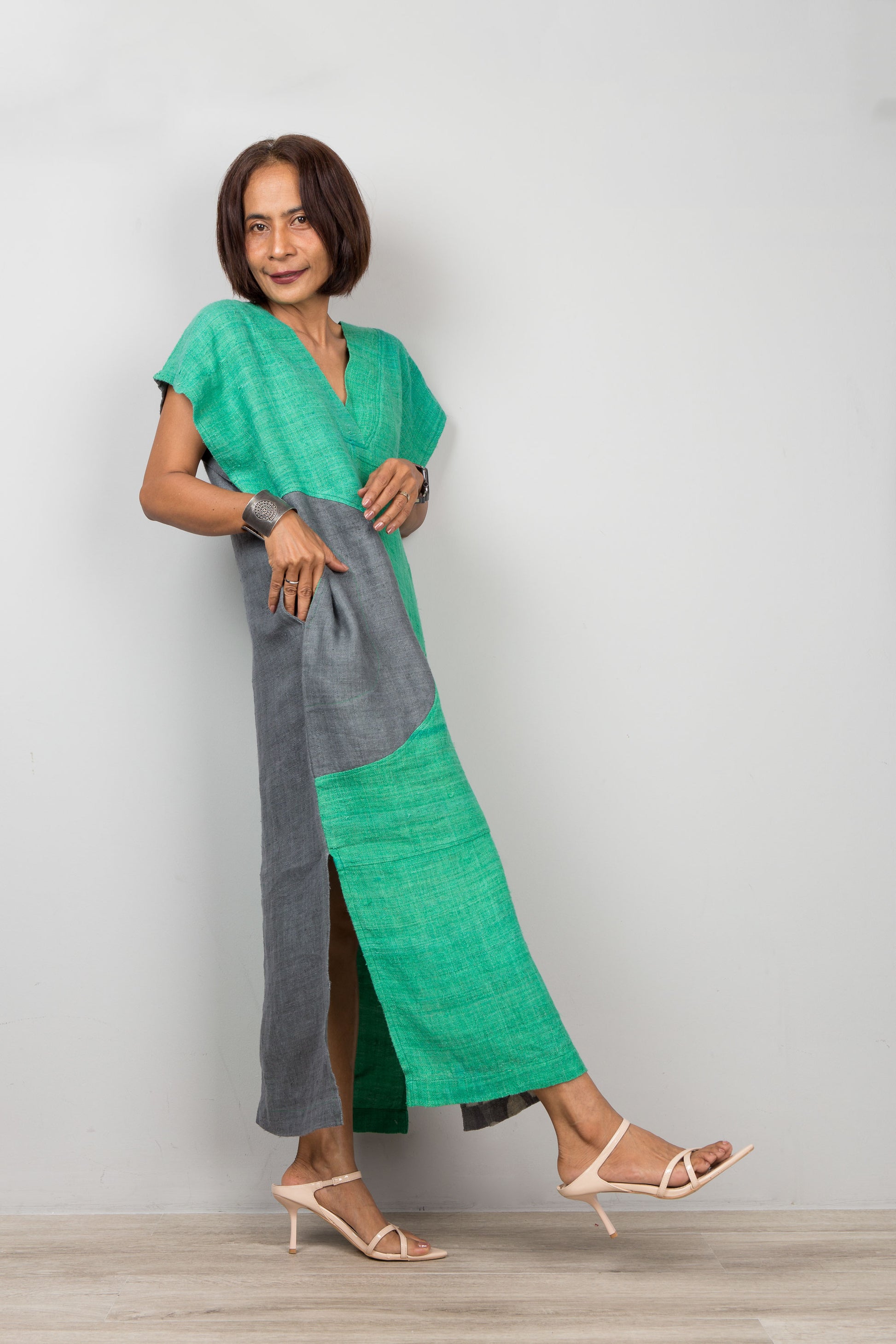 Woman wearing a green and gray dress against a plain background