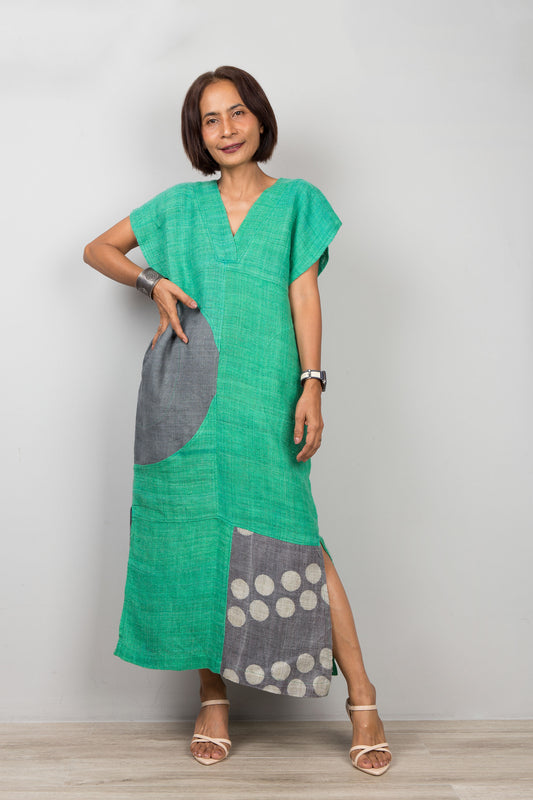 Woman wearing a green and gray patchwork hemp dress with a plain background
