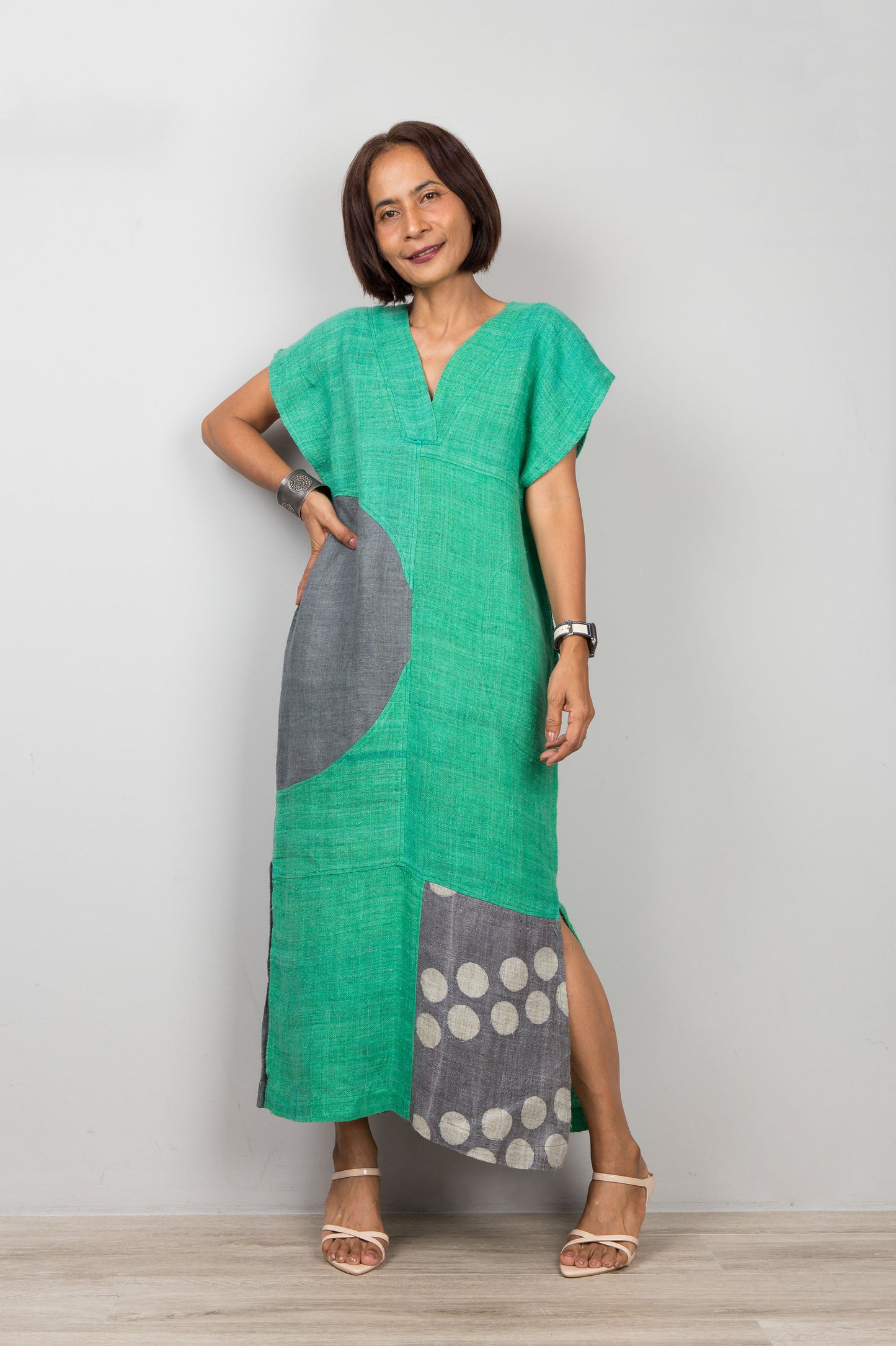 Woman wearing a green and gray dress with a white background