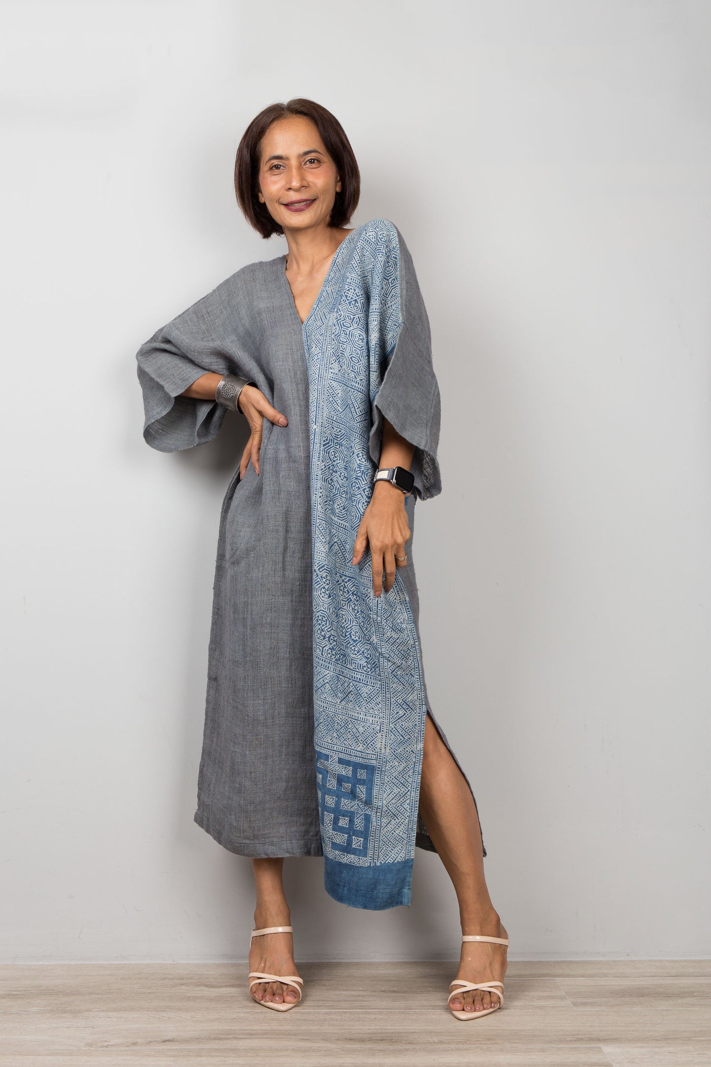 Nuichan wearing a long, light blue and gray dress with a patterned design on a plain background
